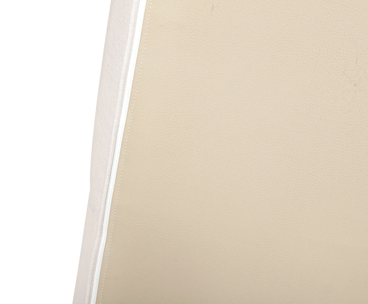 Beige upholstery fabric close-up with visible seam and stitched edge