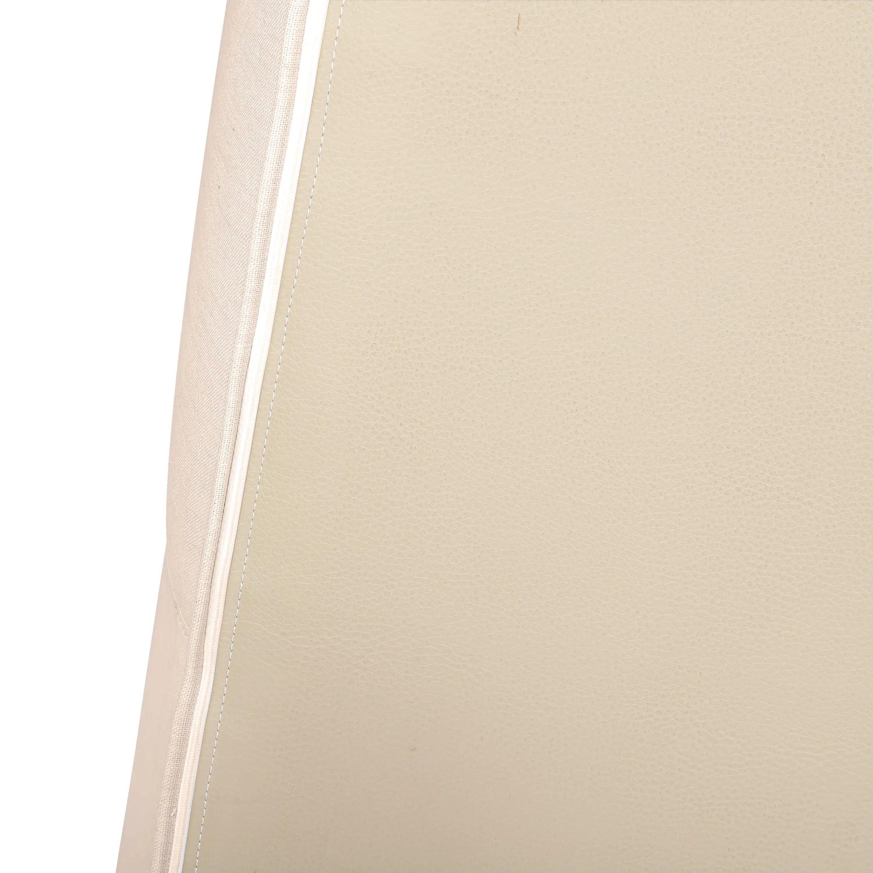 Beige upholstered chair arm panel with stitched seam edge detail