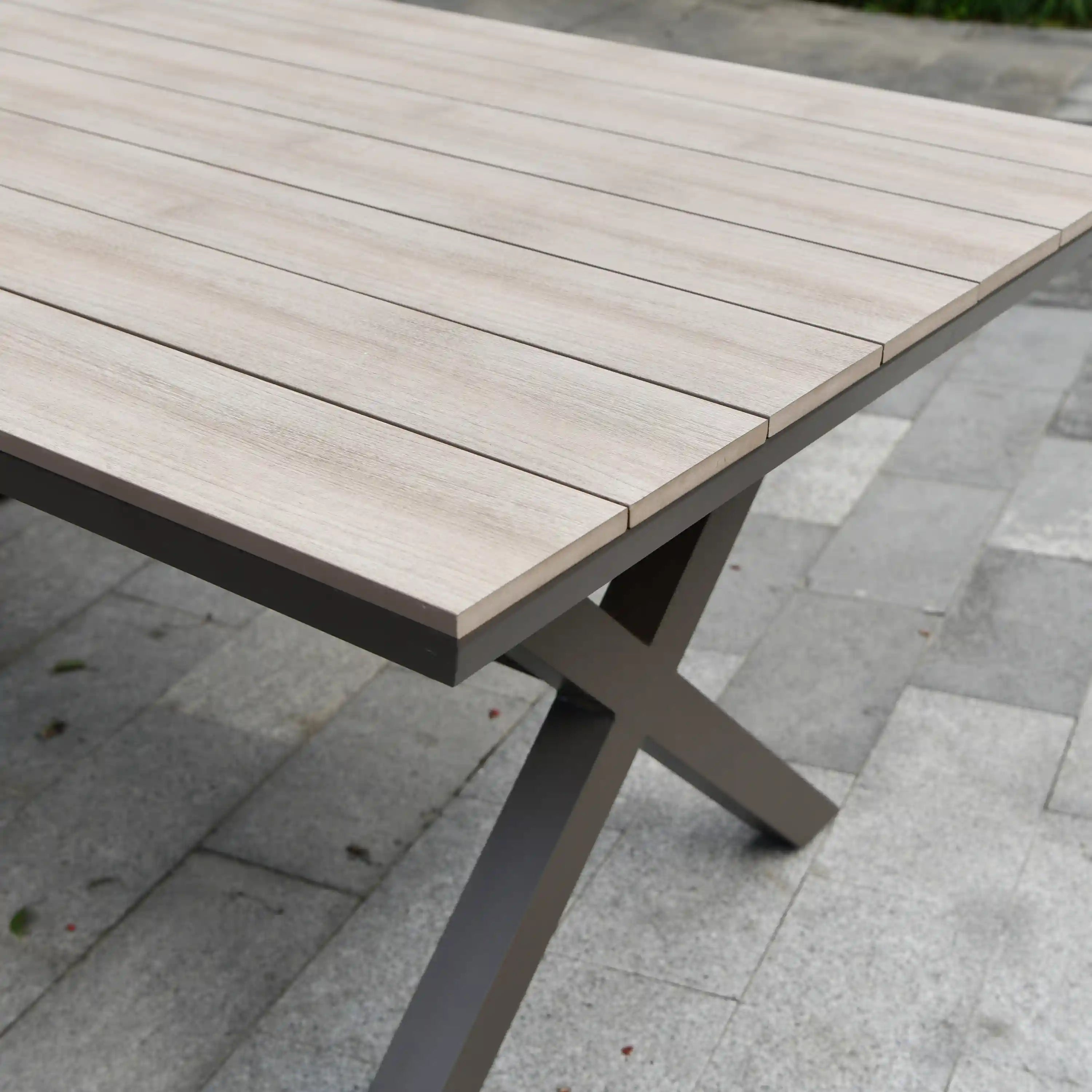 Outdoor dining table with light wood-slat top and dark metal legs