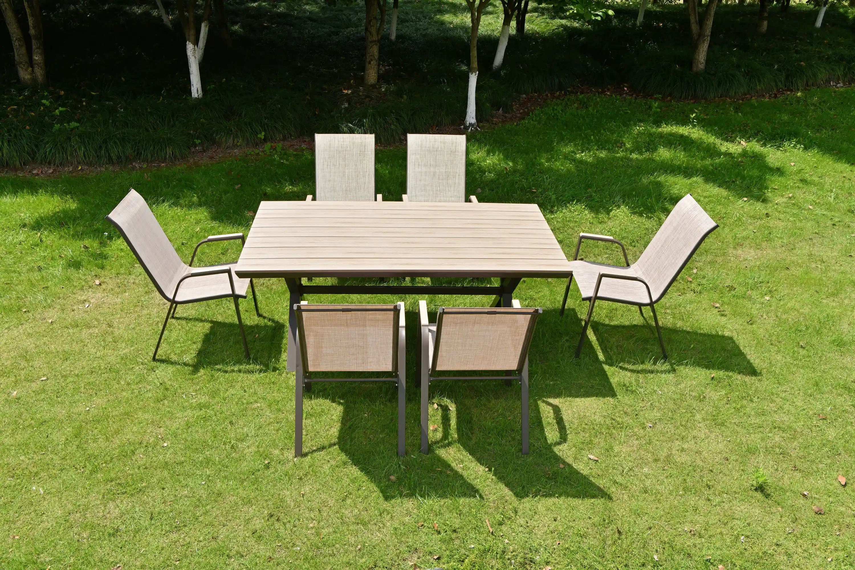 Outdoor dining set on grass with square table and six gray chairs