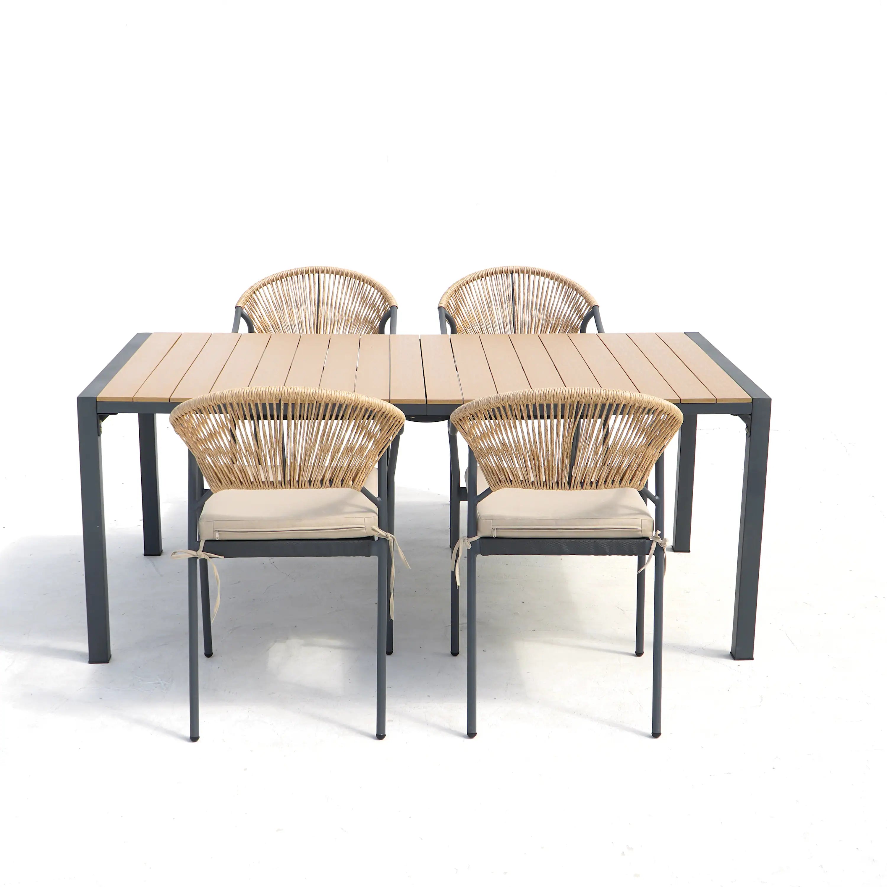 Outdoor patio dining table with four wicker chairs; light beige seat cushions and dark frames.