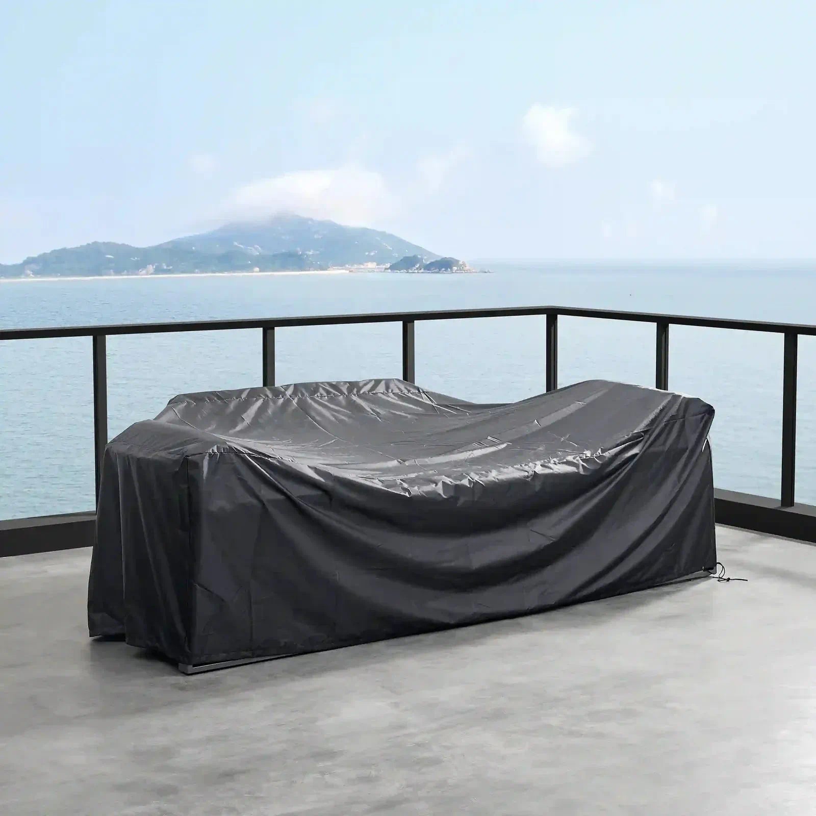 Outdoor firepit covered with a black protective cover tied at the corners