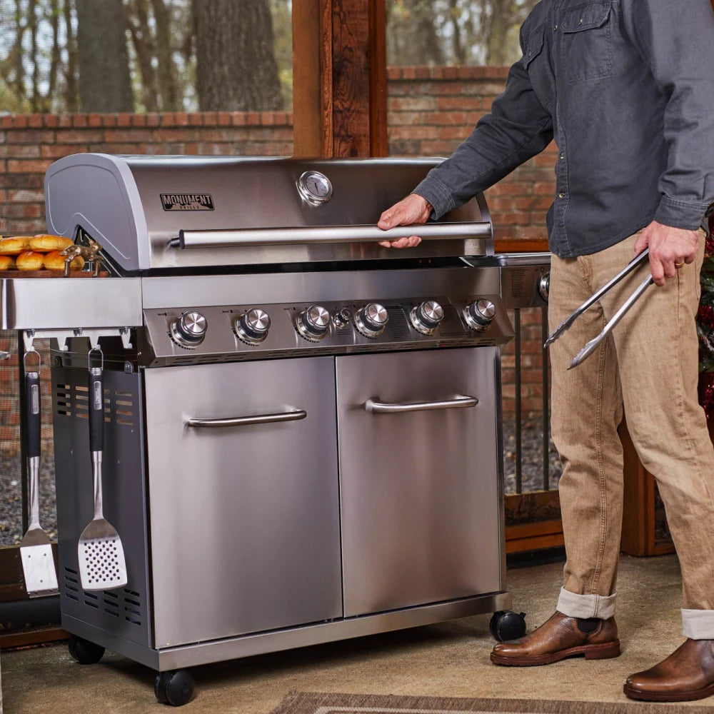 Stainless steel propane gas grill with side prep shelves and open cabinet doors