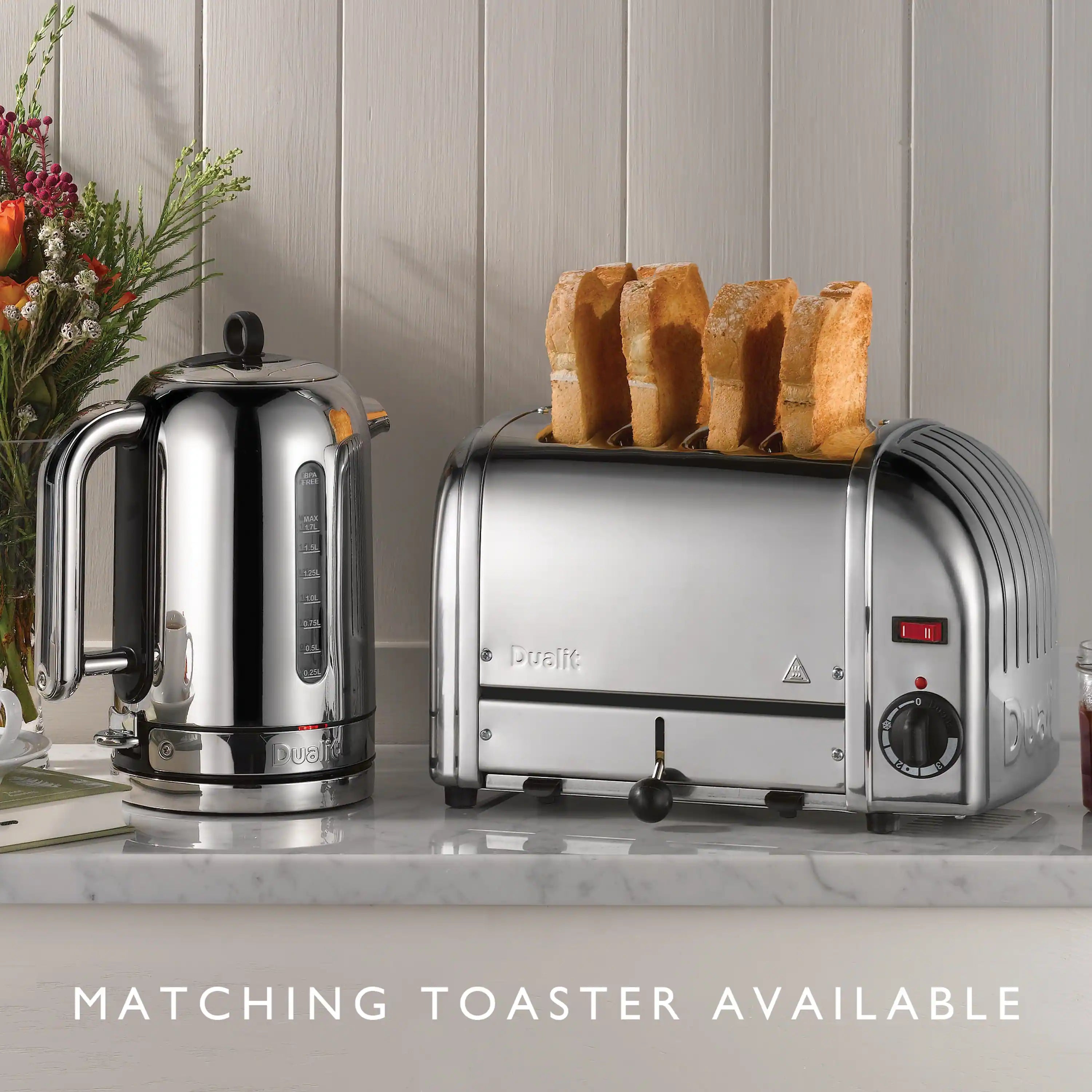 Polished chrome electric kettle with curved handle and spout, standing on a counter.