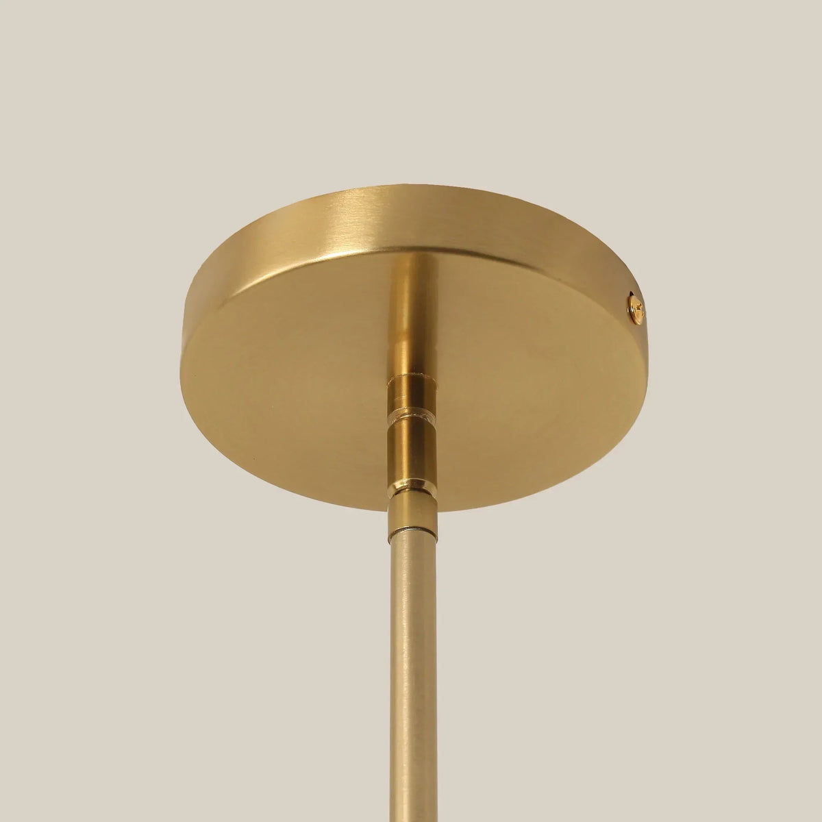 Golden ceiling canopy and straight stem of a 1-light island pendant light