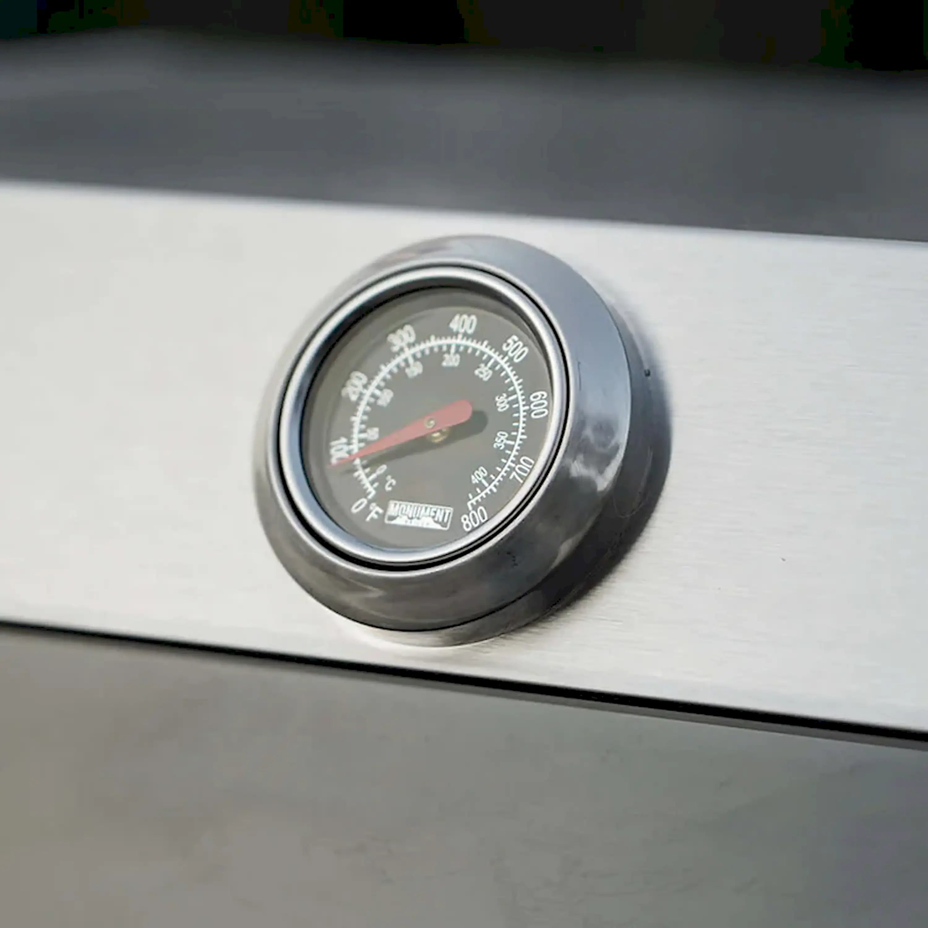 Propane grill temperature gauge with dial on stainless steel lid