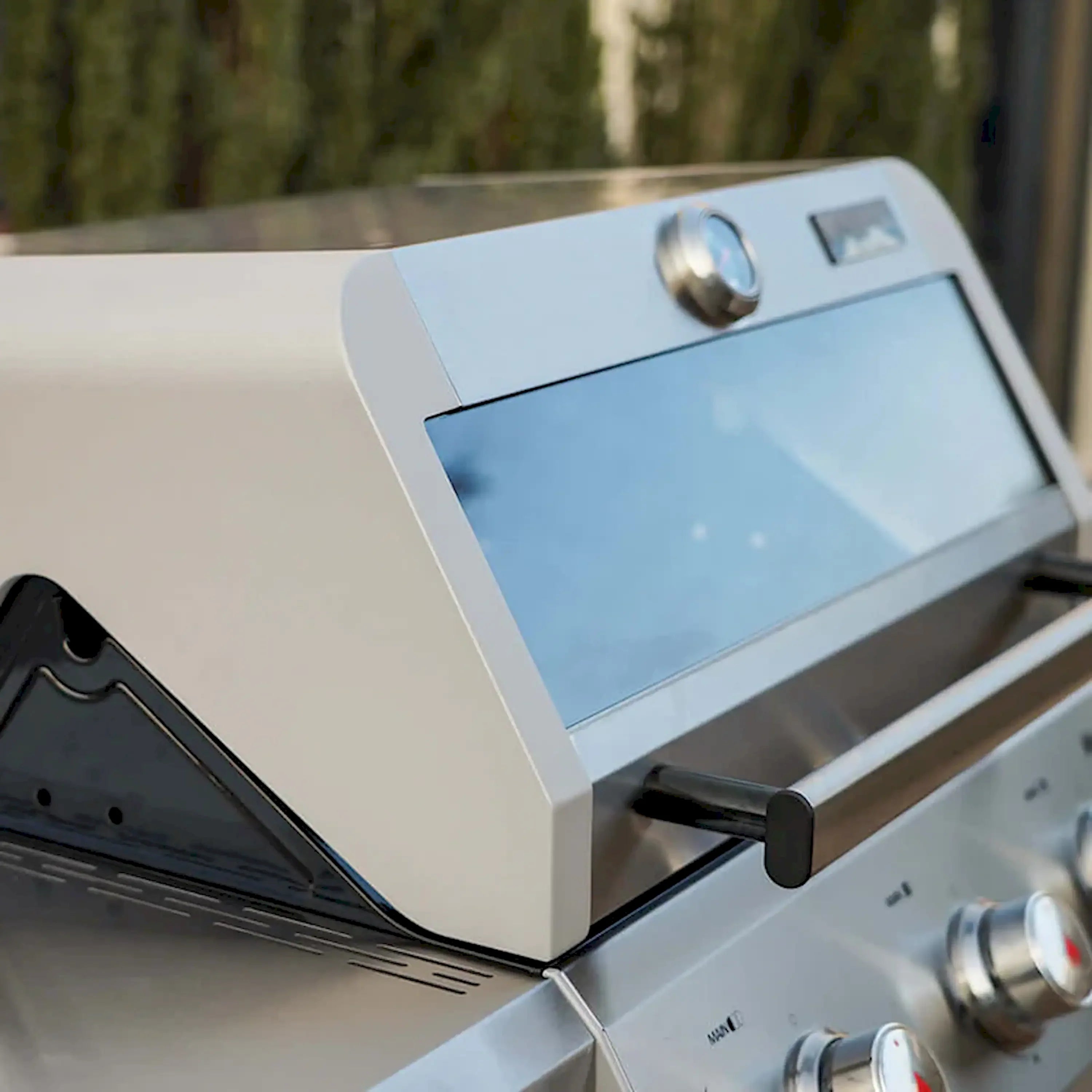 Open lid of stainless steel propane grill with control panel and side rack