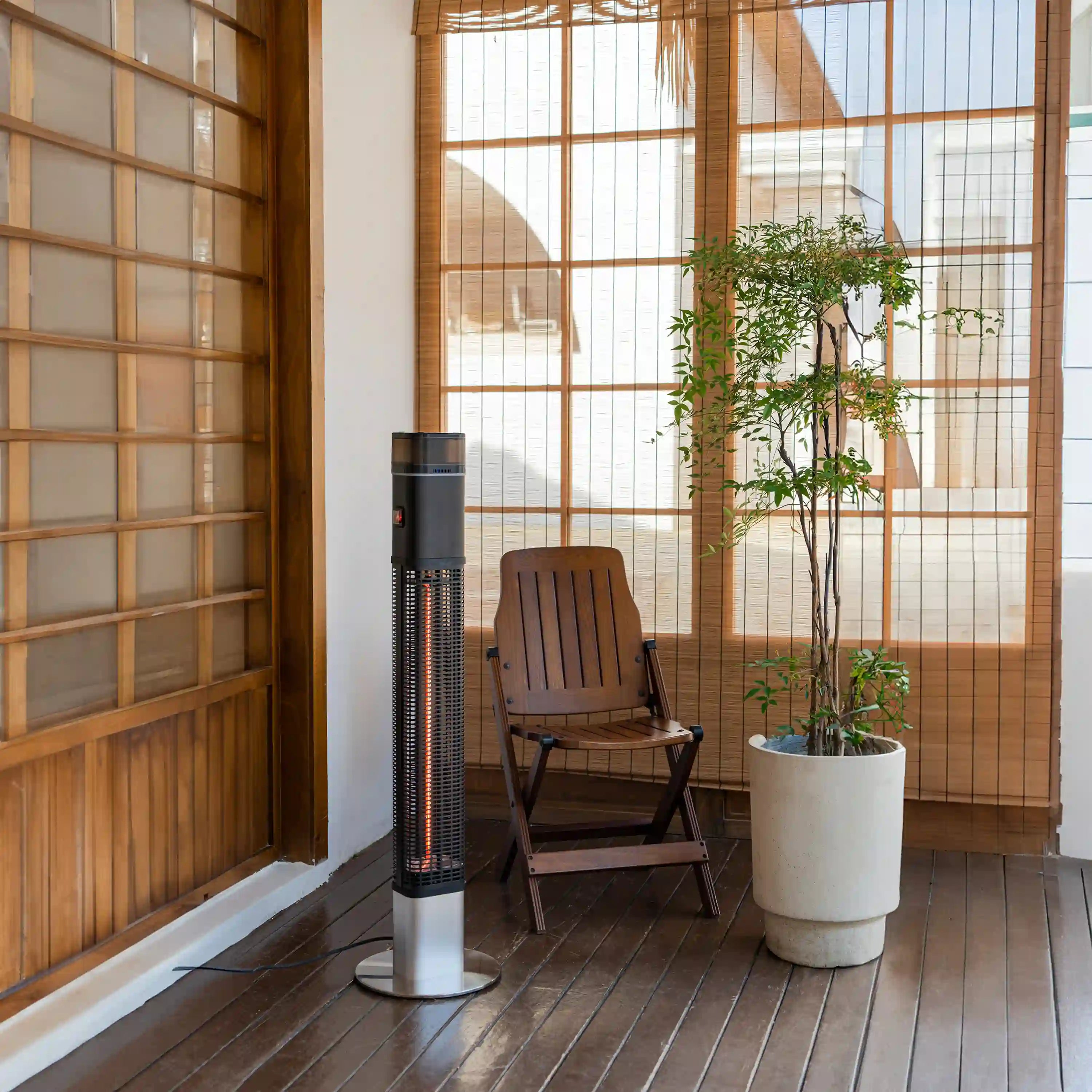 Black electric column heater with halogen tube and protective grill on stand
