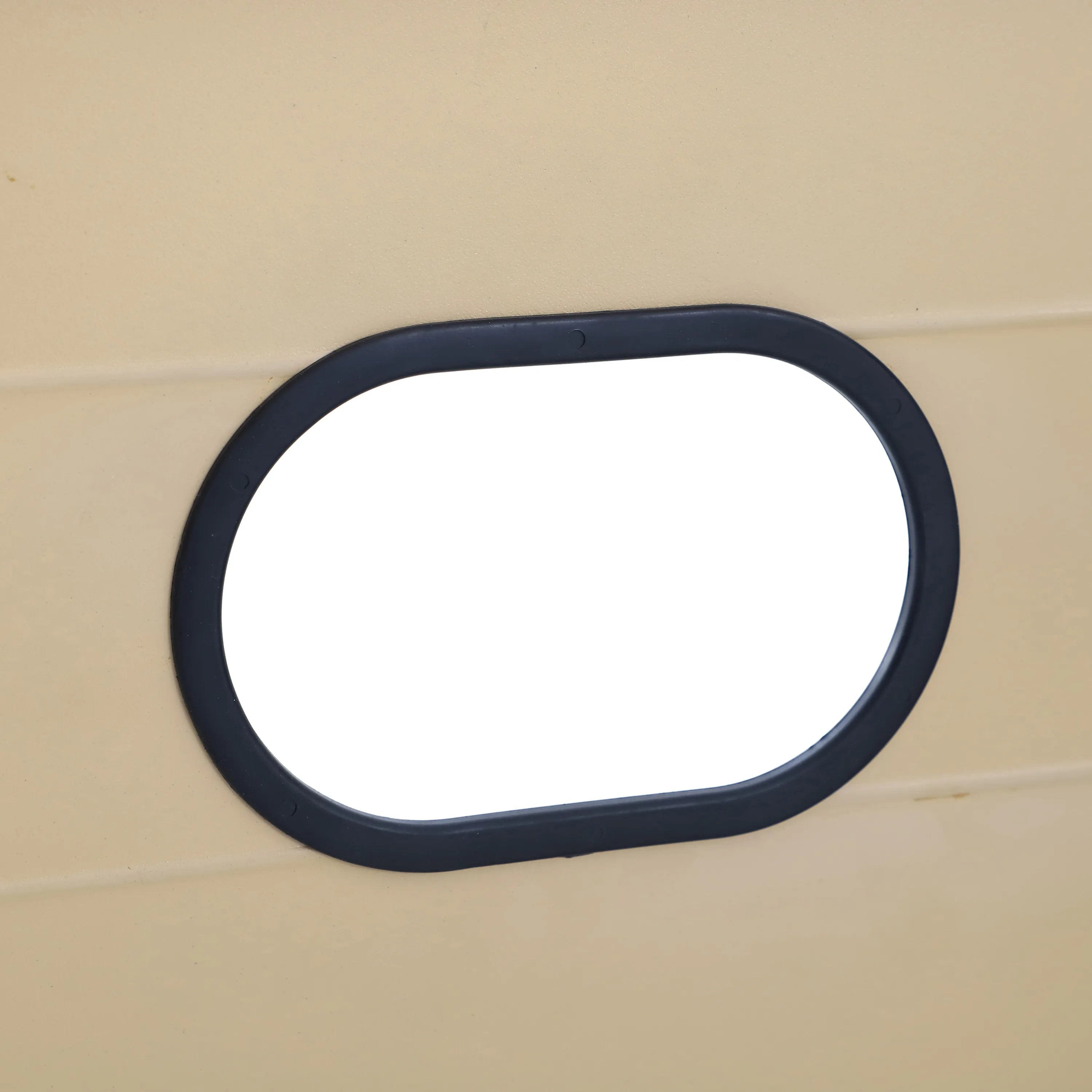 Black oval trim on tan wood panel for propane fire pit table access