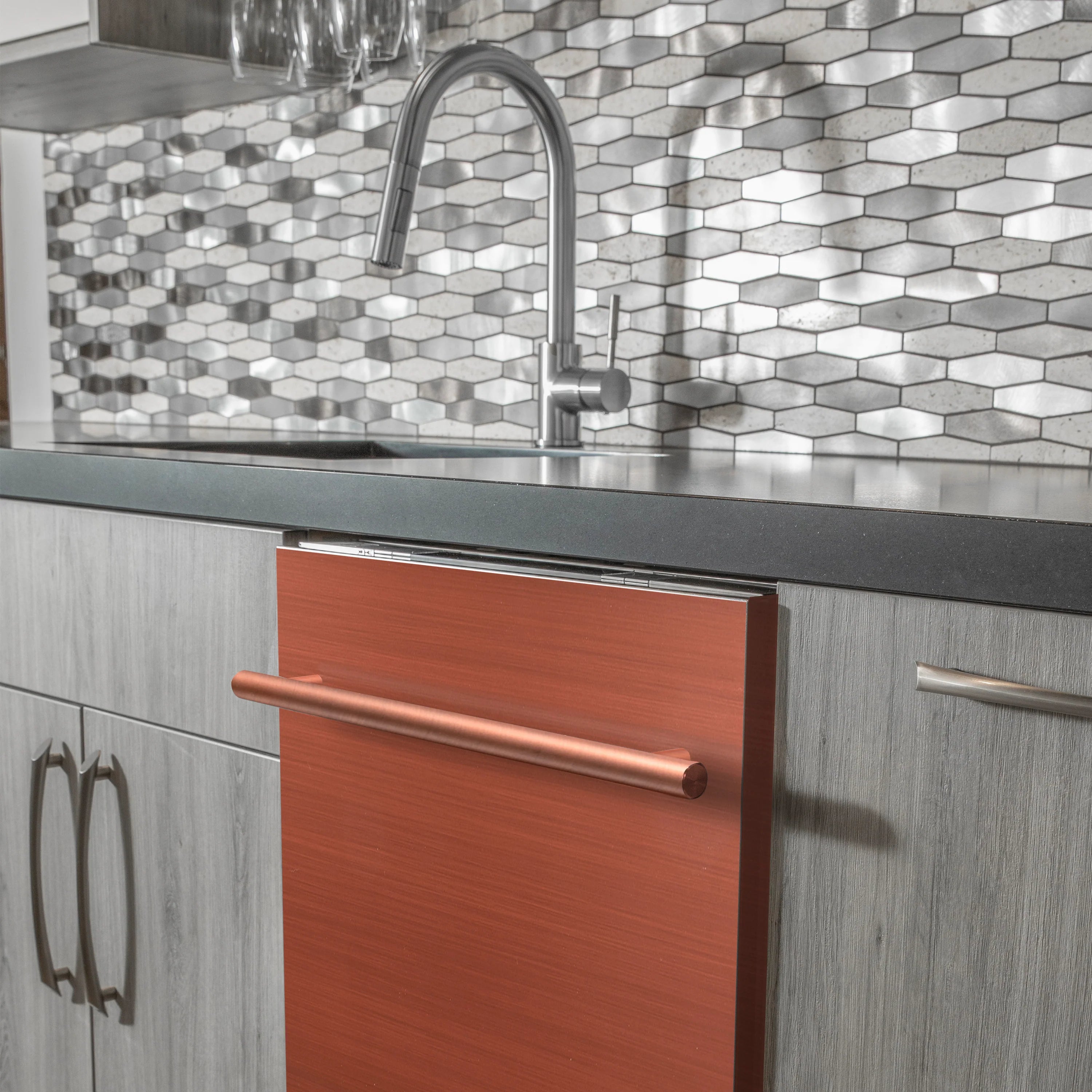 Undercounter dishwasher with copper door and stainless steel bar handle beneath sink
