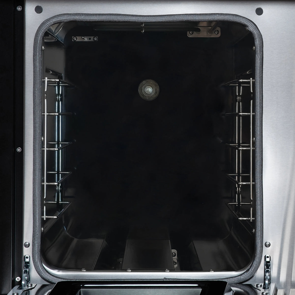 Open oven cavity with racks and black interior walls inside a dual-fuel range