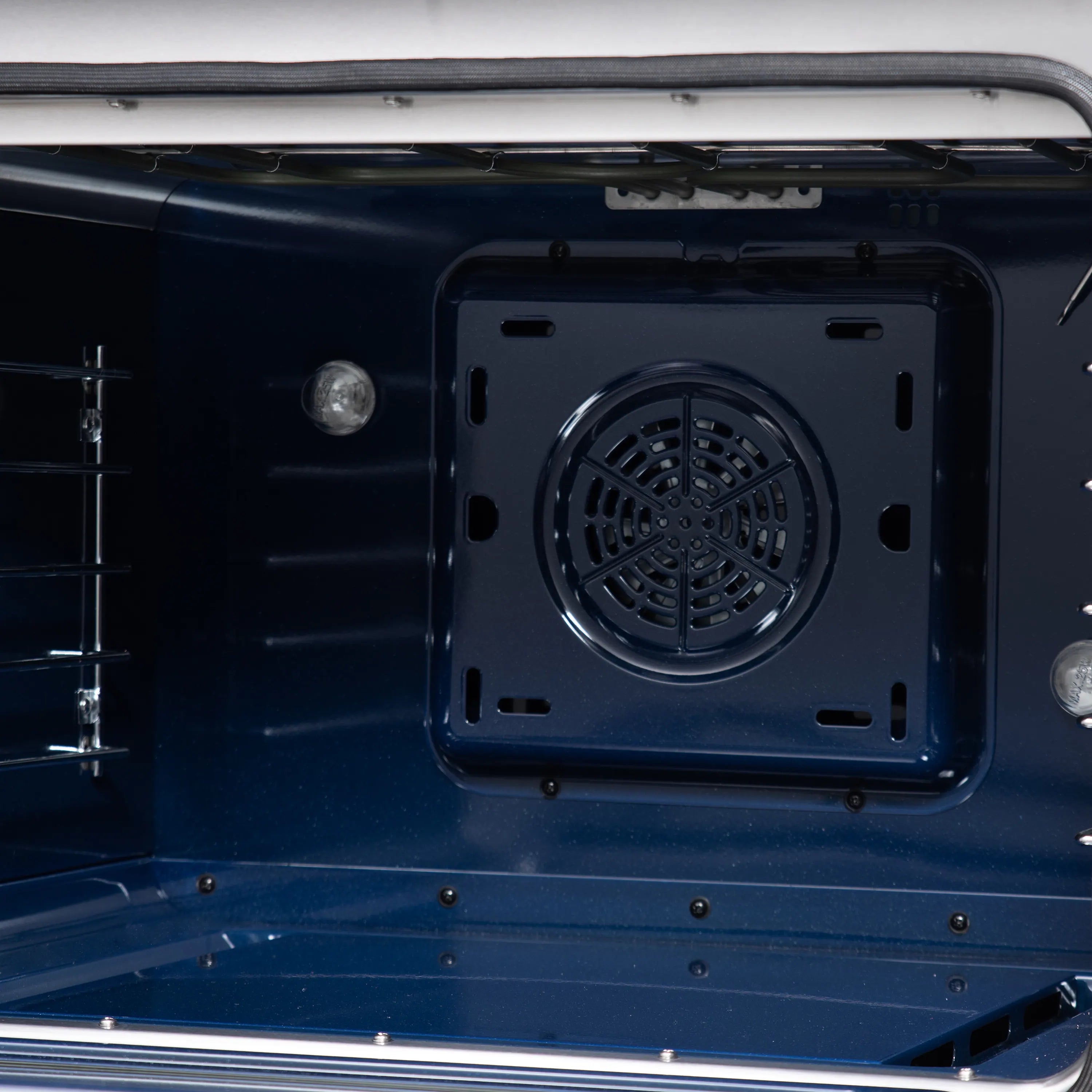 Convection oven interior with dark rear vent panel and oven racks inside the range