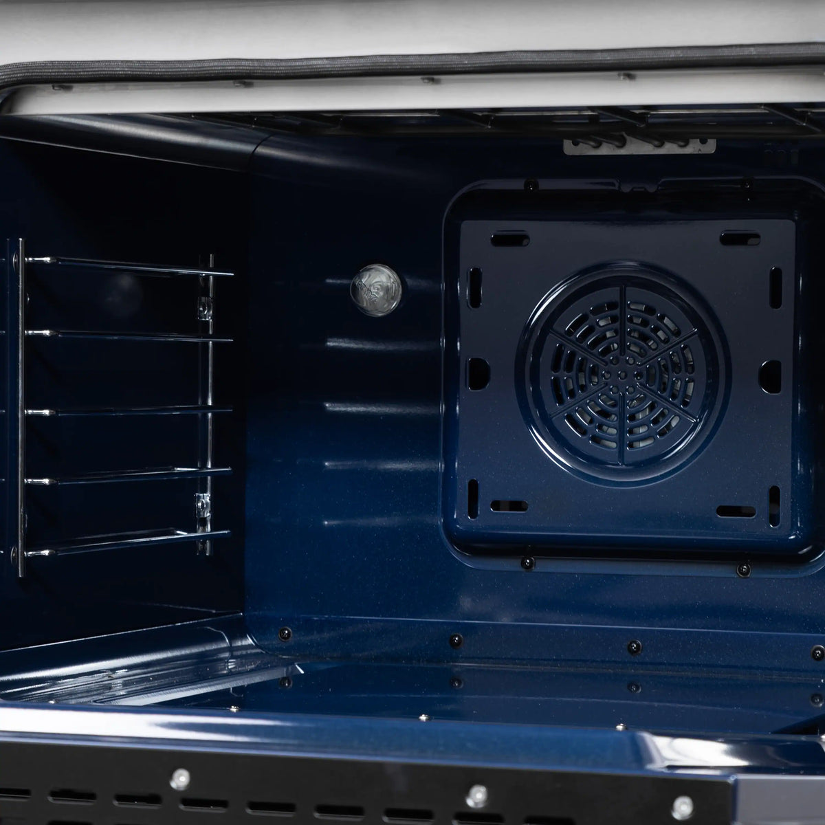 Convection oven interior with blue enamel, rear fan vent panel, and metal racks