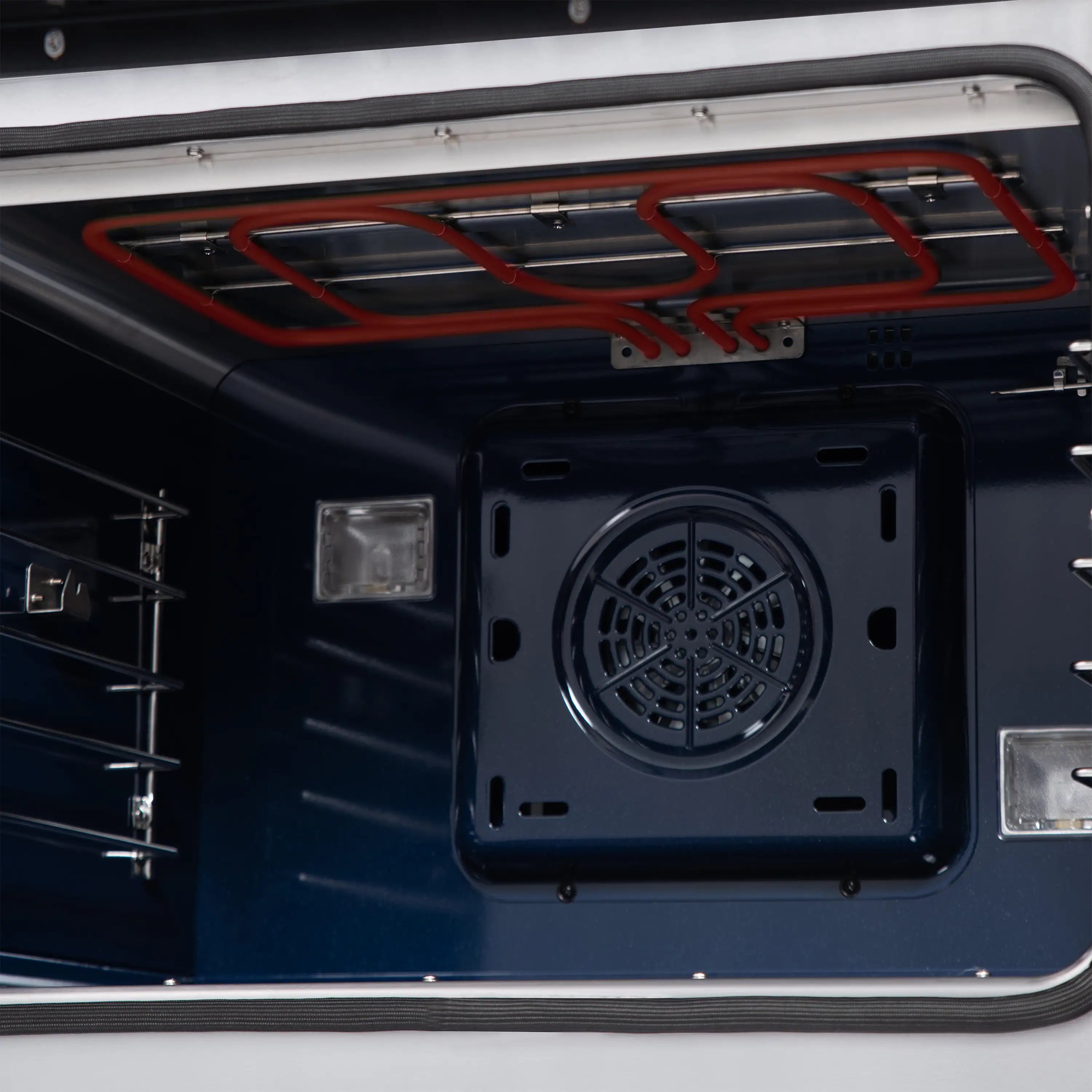 Dual fuel range oven interior close-up with red gas lines and ventilation opening
