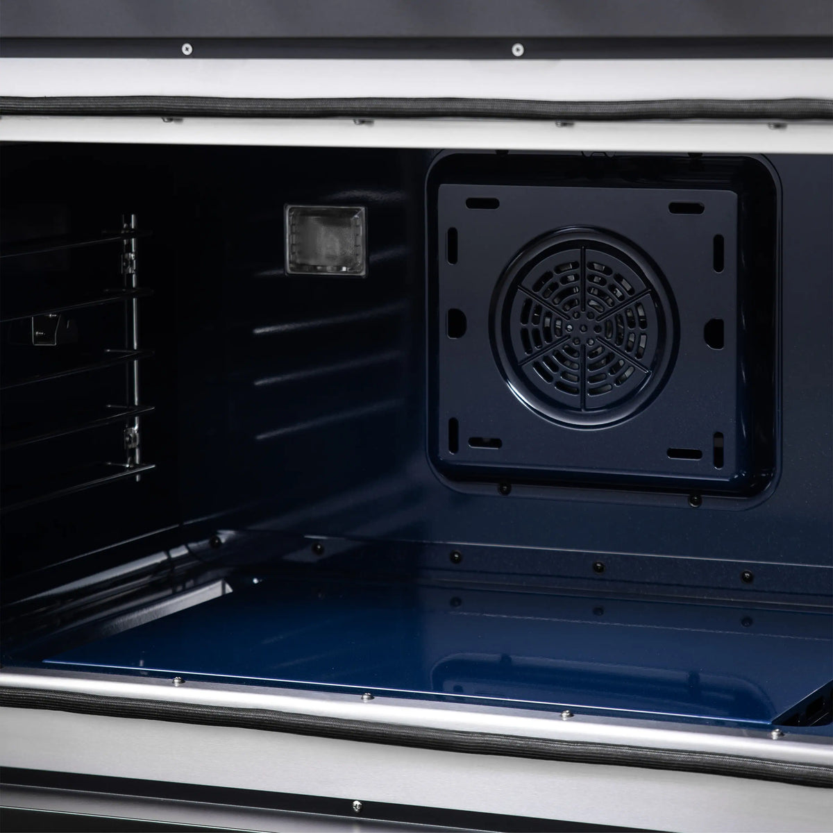 Freestanding dual fuel range oven interior with circular fan vent panel