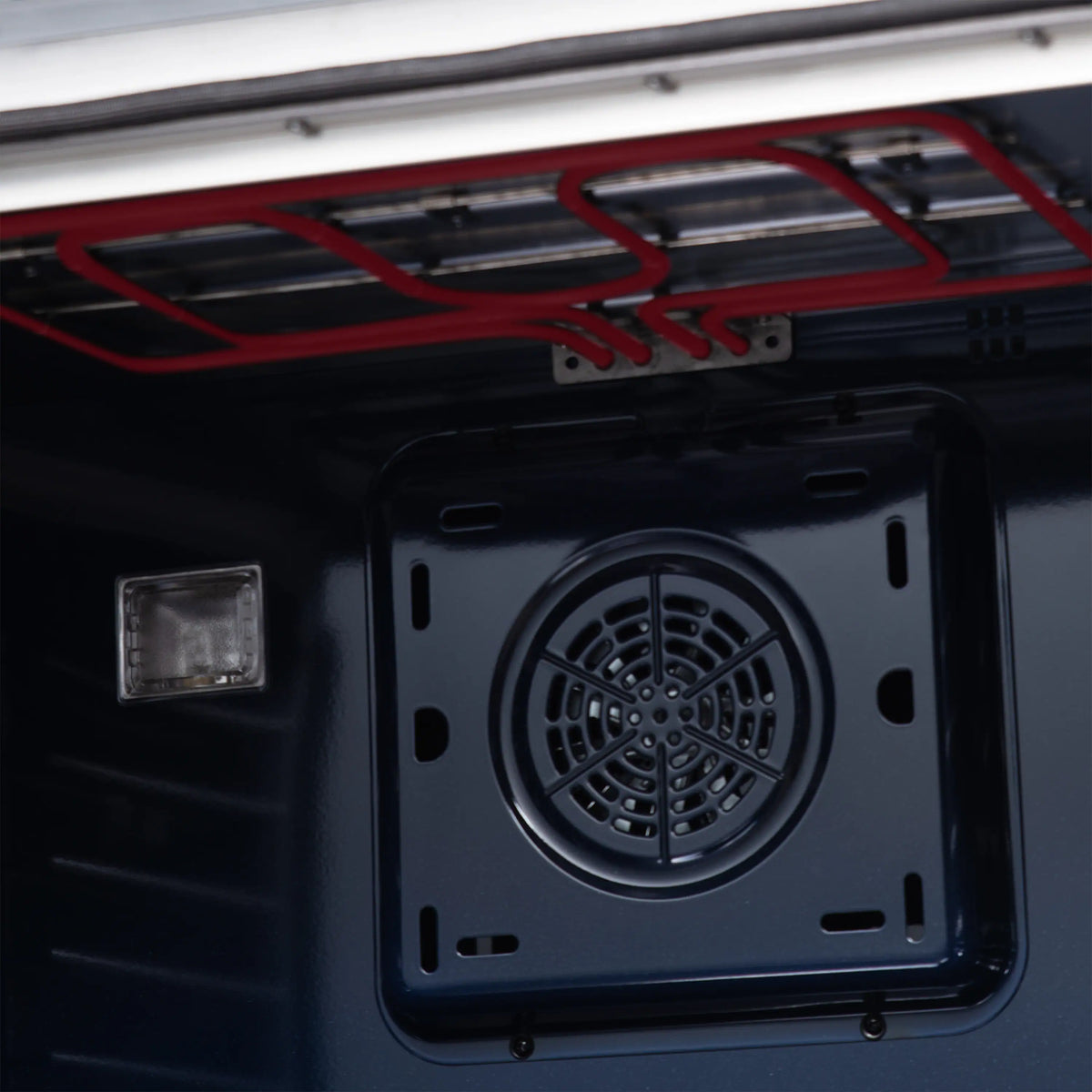 White dual fuel range oven interior with red broil element and circular fan cover