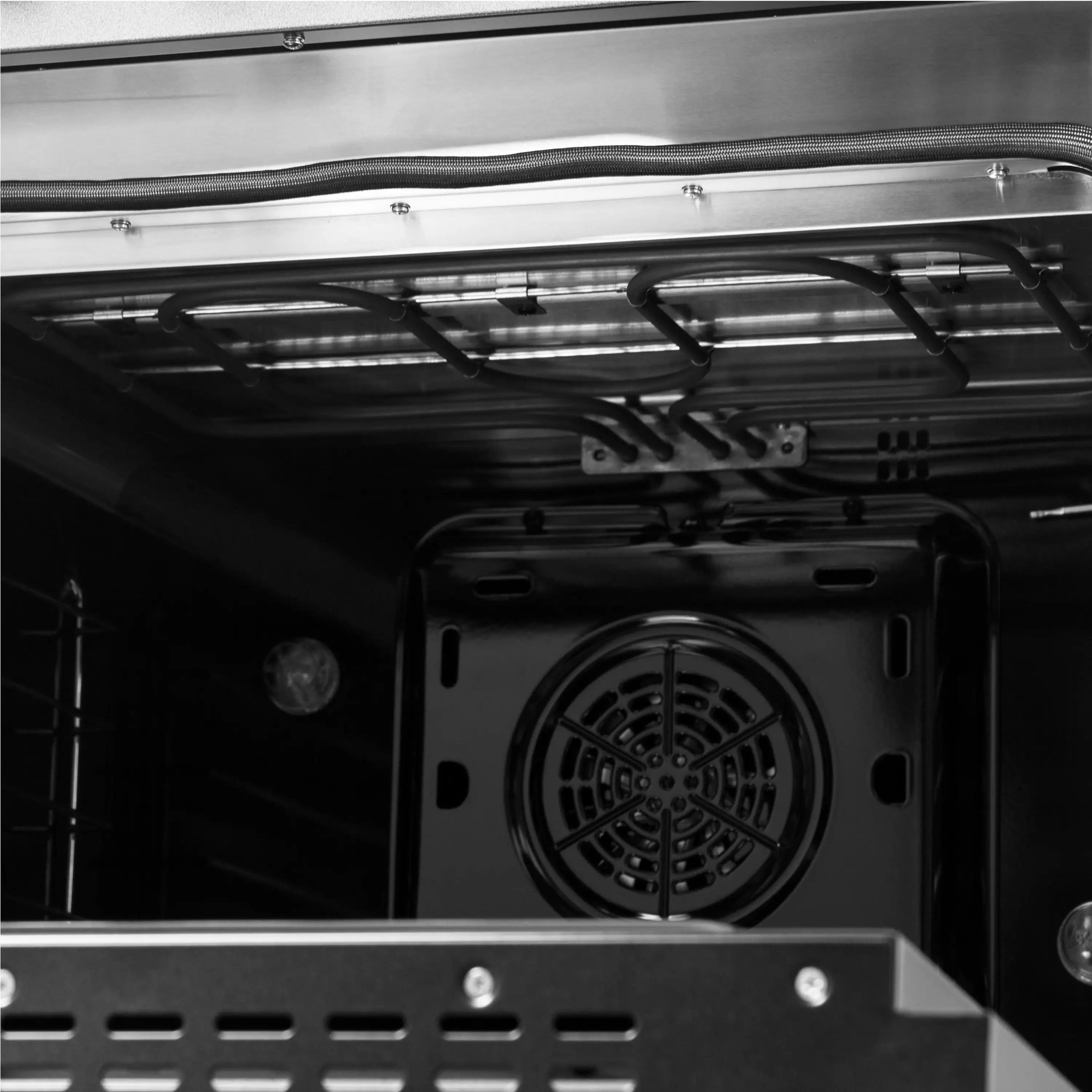 Black oven interior with upper heating hardware and circular convection fan housing