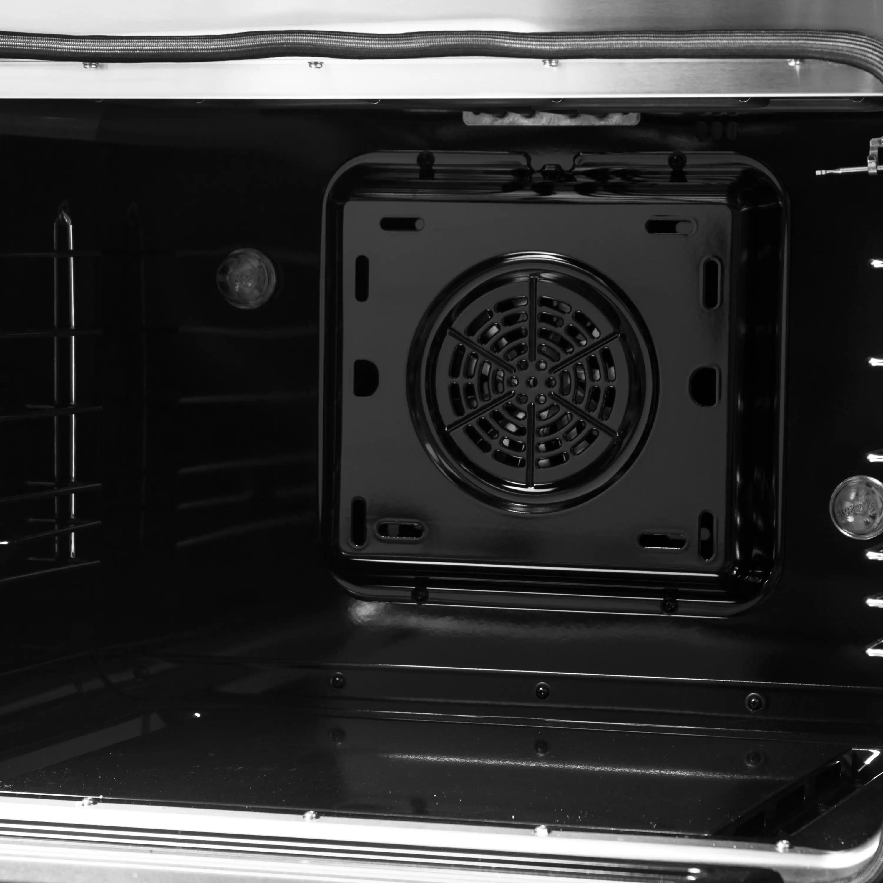 Black oven cavity with circular convection fan housing and side rack guides