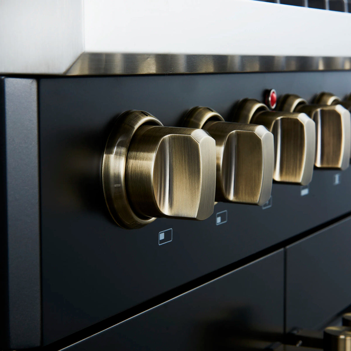 Black dual fuel range with antique brass control knobs on front panel