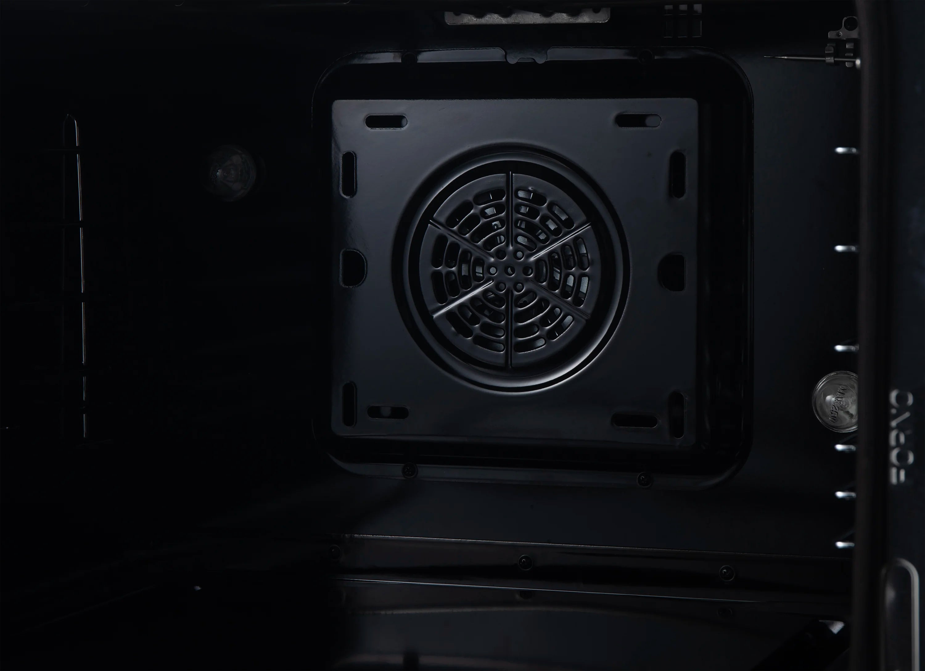 Dual fuel range oven fan and circular burner cover viewed from inside oven.