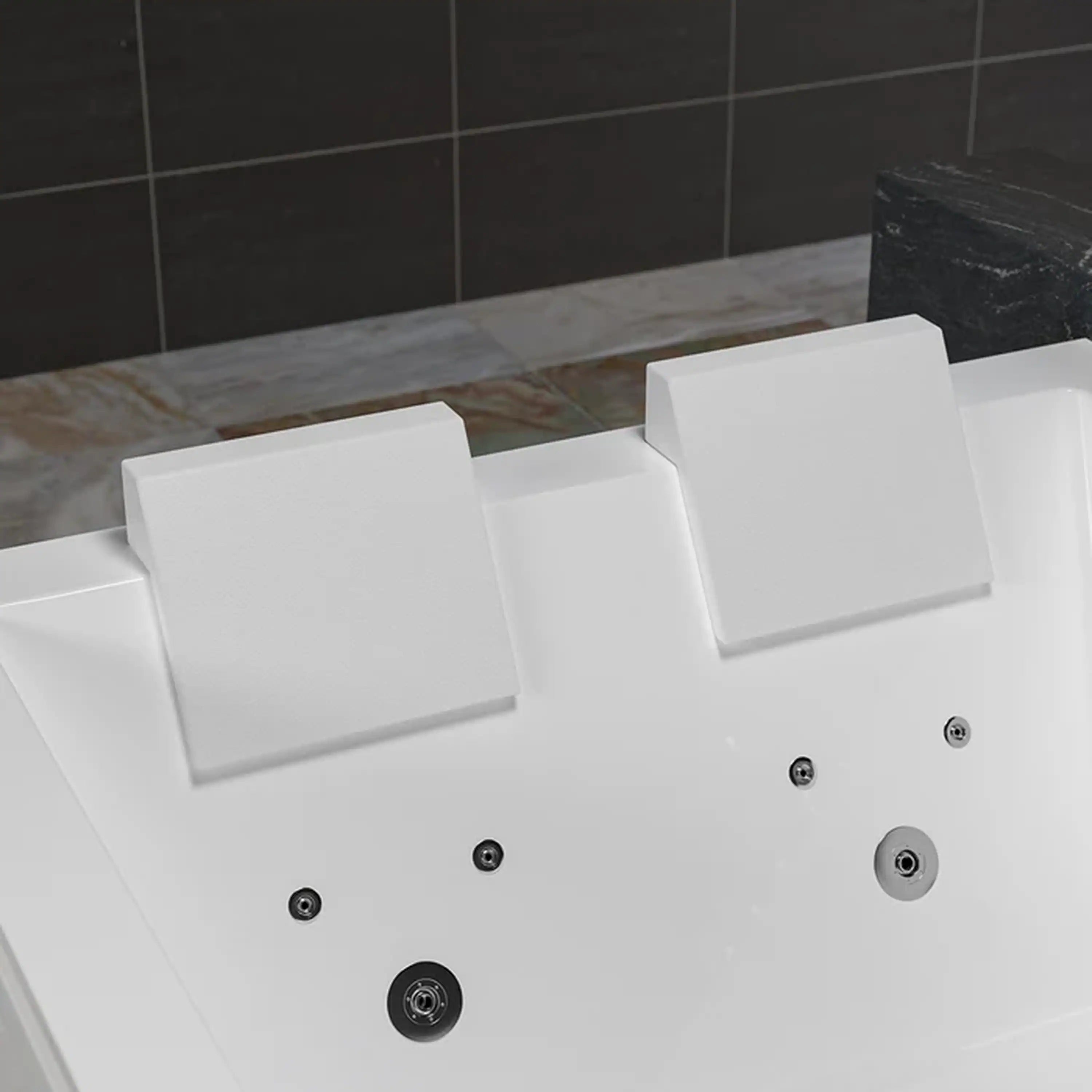 White whirlpool bathtub interior with massage jets and outlet ports on wall