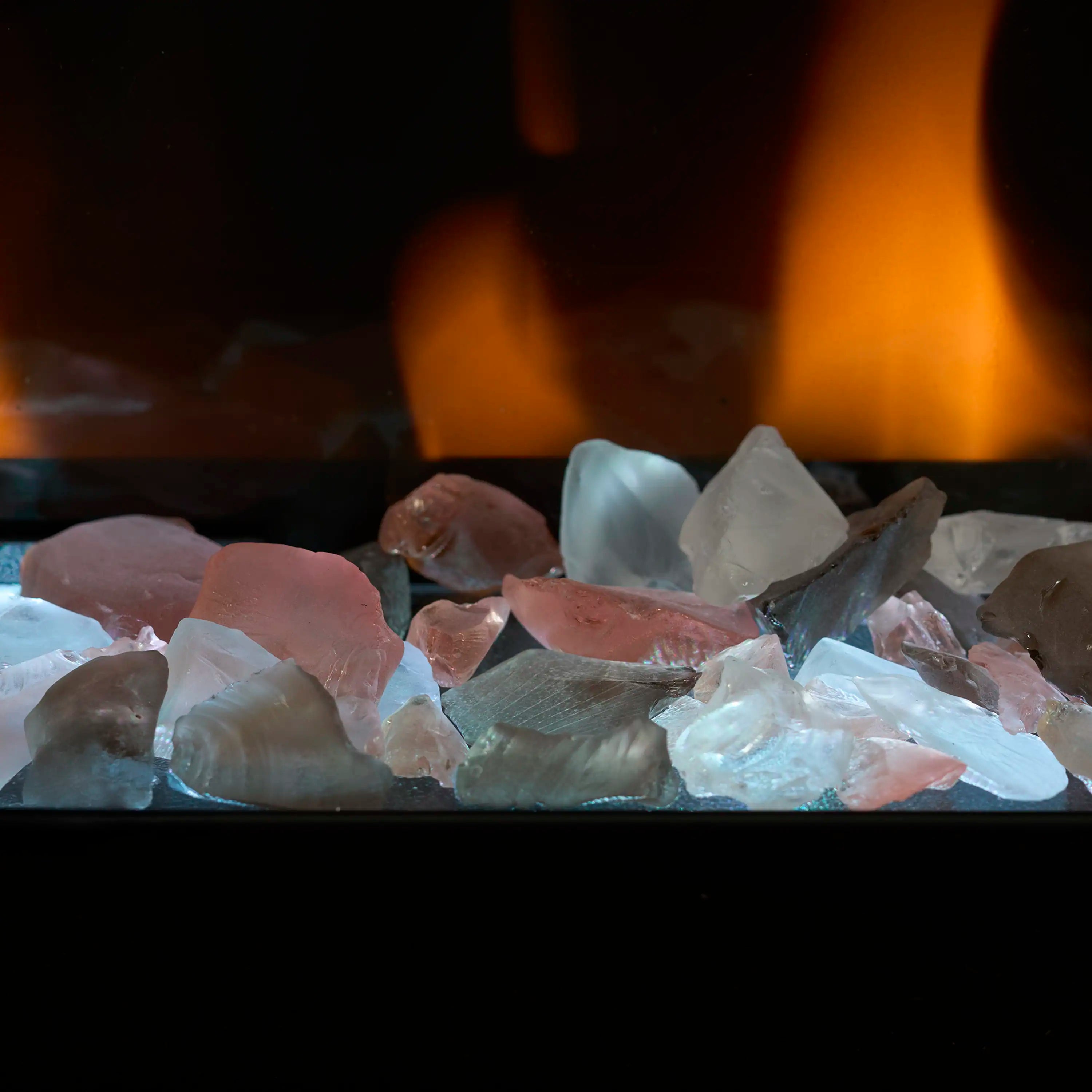 Electric fireplace ember bed with blue glass and clear rocks glowing under orange flames