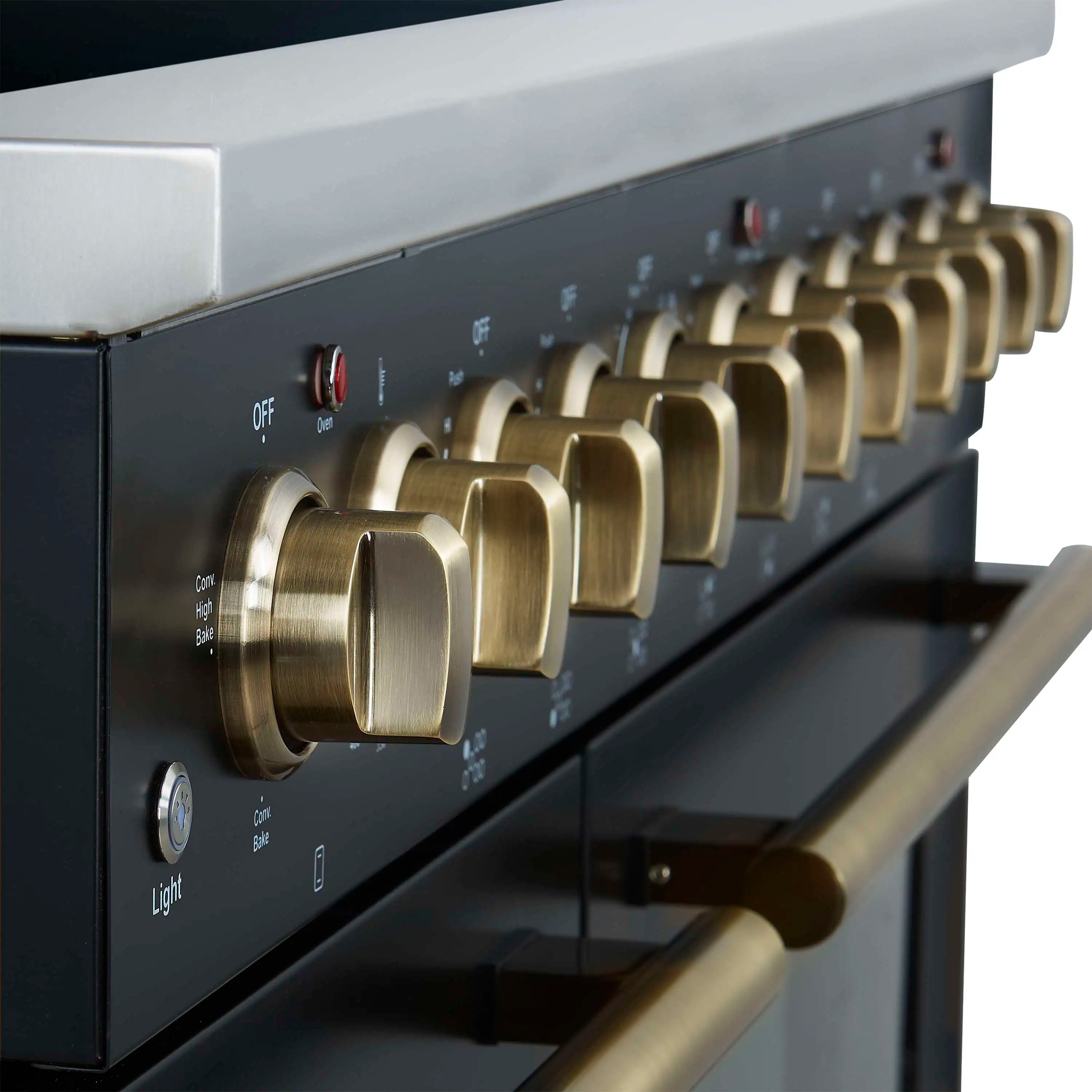 Close-up of black electric range control panel with gold-tone round burner knobs