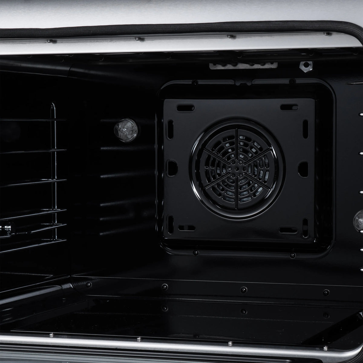 Black electric range oven cavity with round convection fan in back panel