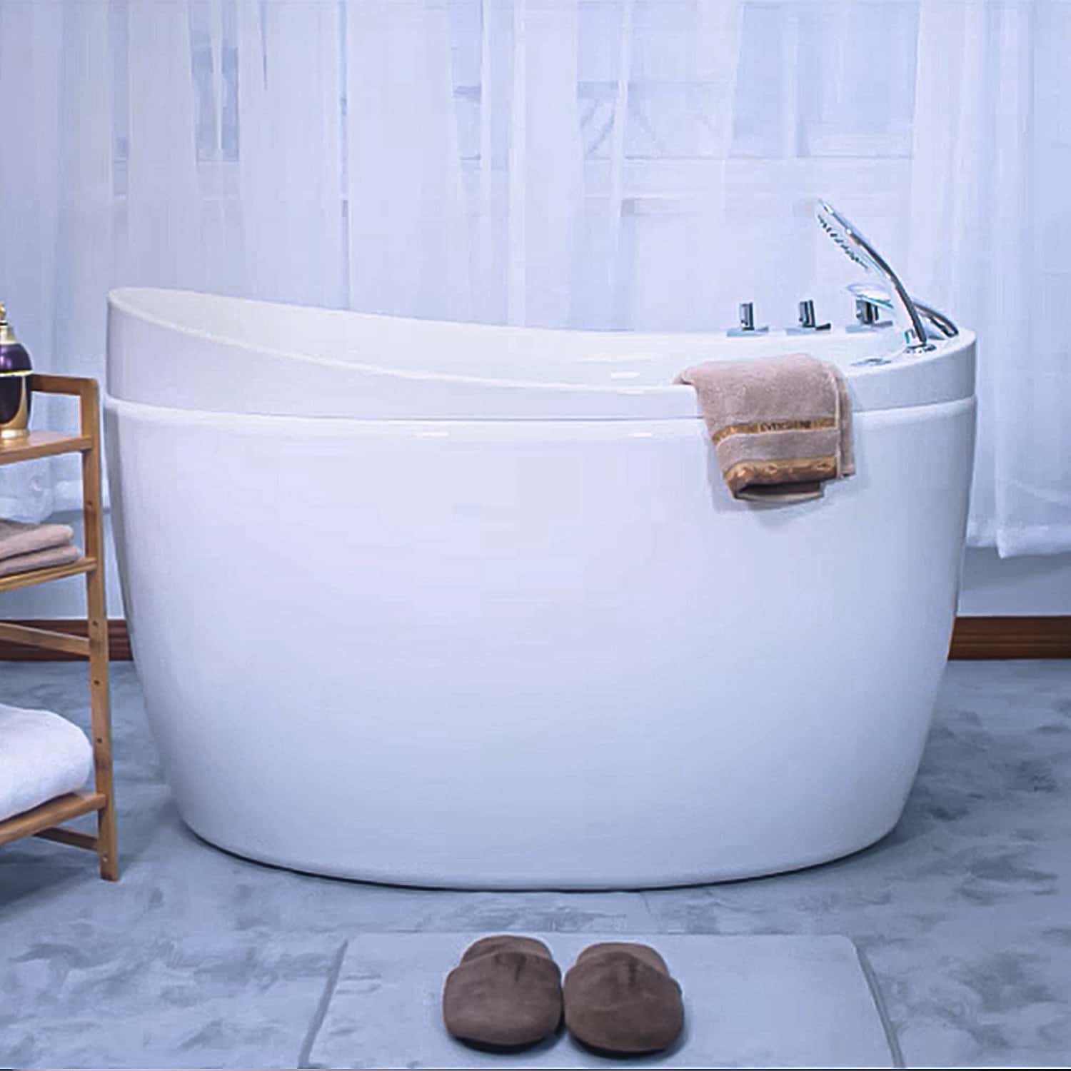 White freestanding air bathtub with chrome faucet and a towel on the rim