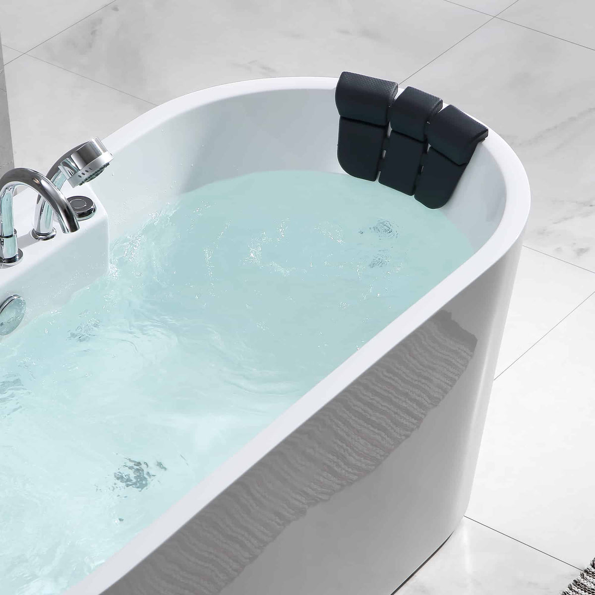 Close-up of white whirlpool bathtub edge with blue water and black headrest cushion.