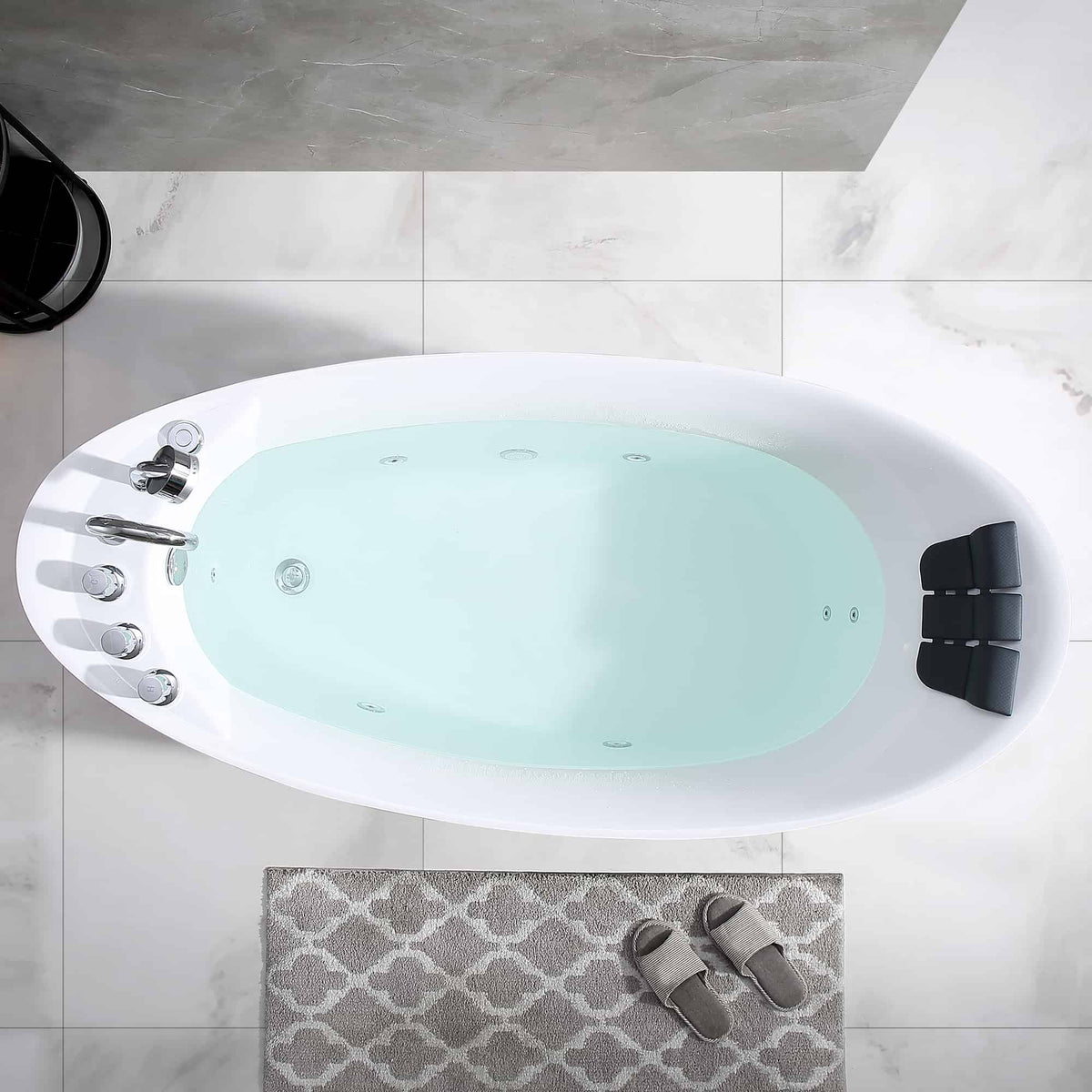 Top view of white acrylic whirlpool bathtub with black headrests and chrome fittings
