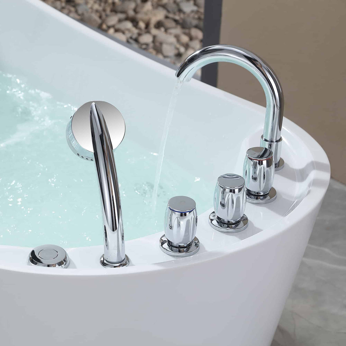 Chrome whirlpool bathtub faucet and controls on white acrylic tub deck.