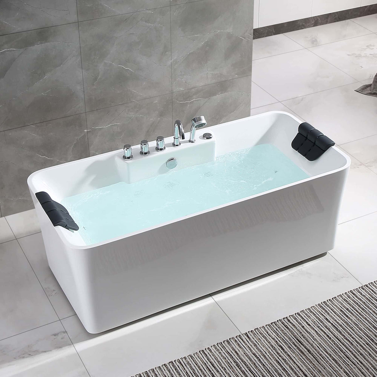 Freestanding white whirlpool acrylic bathtub with chrome fixtures and two black headrests