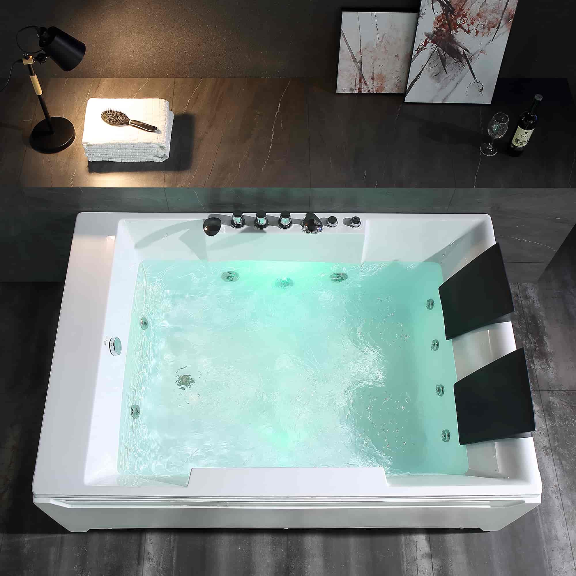 White rectangular whirlpool tub with chrome controls, jets, and two black headrests