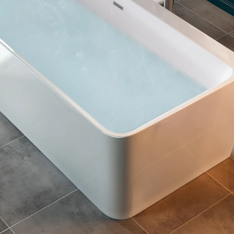 Corner close-up of glossy white soaking tub with water-filled interior and smooth edges.
