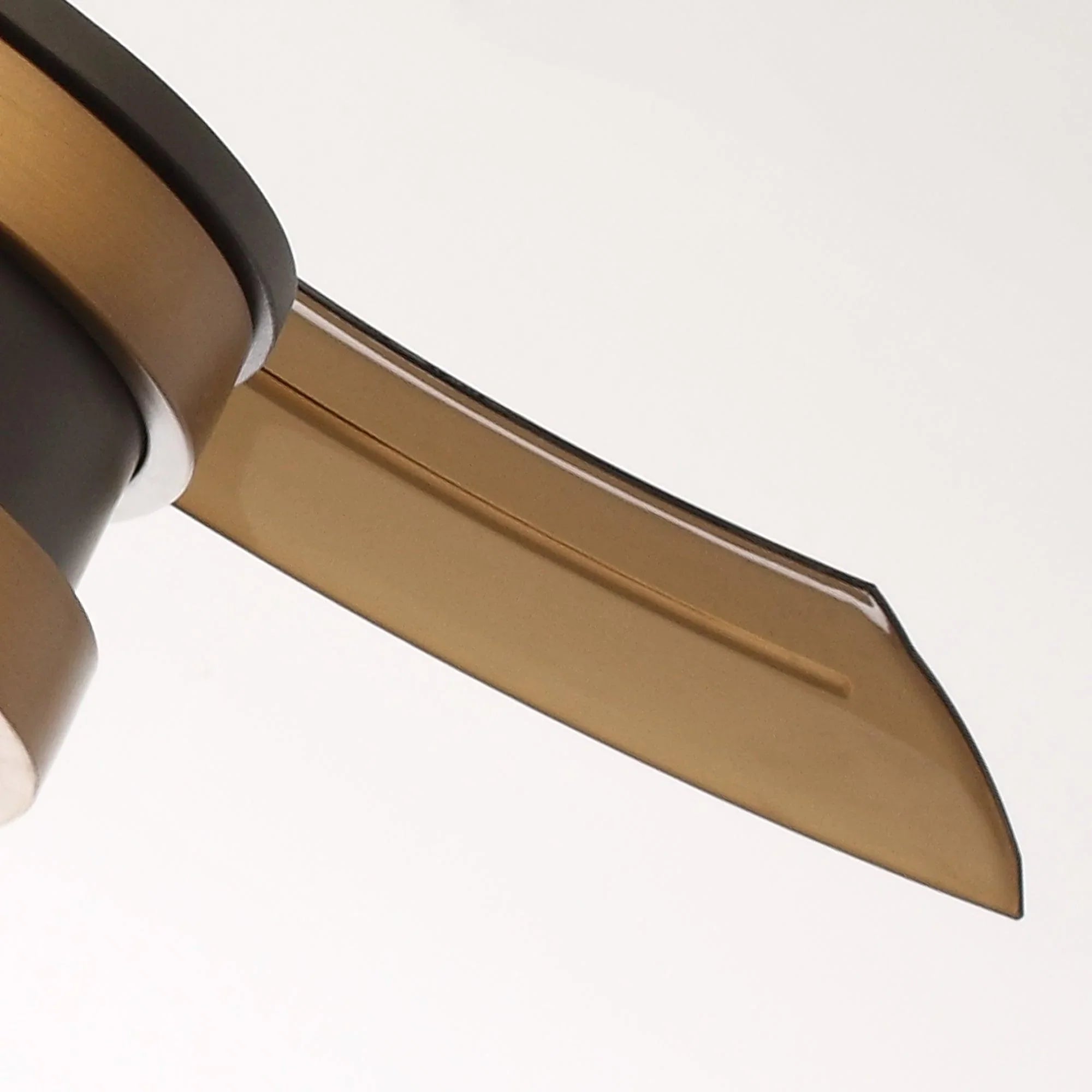 Close-up of bronze ceiling fan blade attached to a black motor housing.