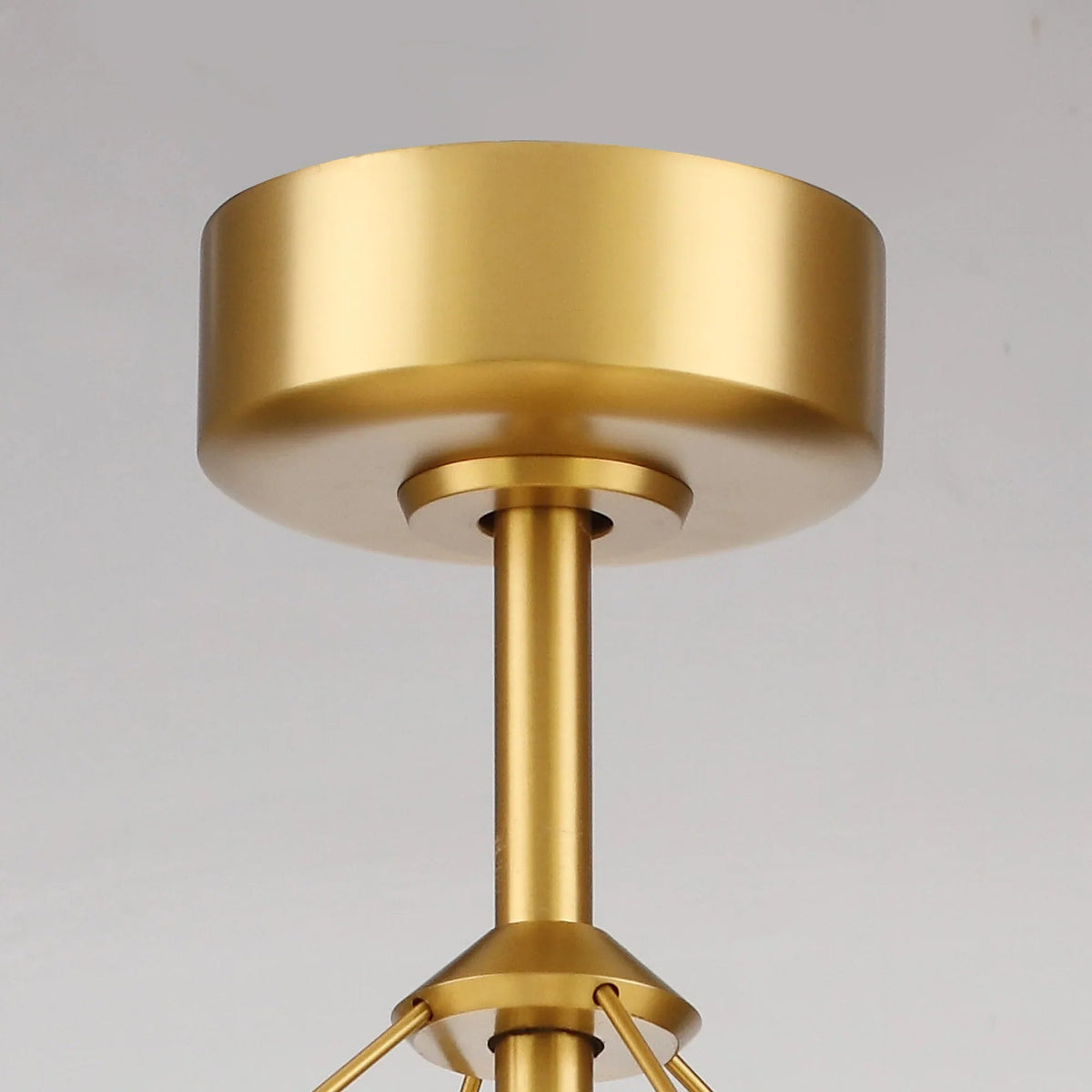 Gold ceiling fan canopy and motor housing with central downrod connection.