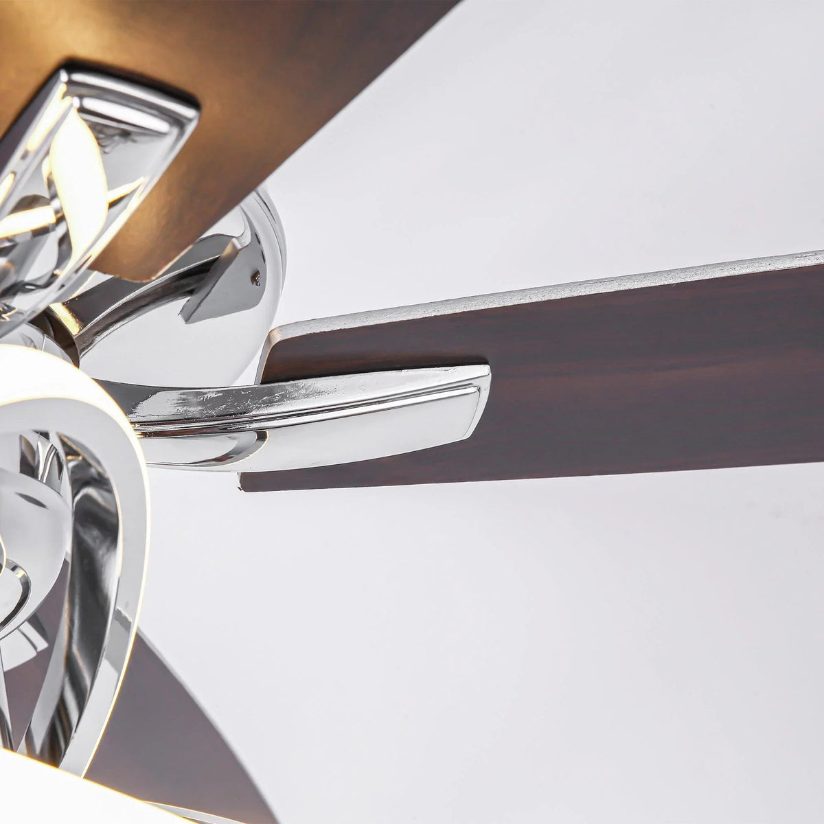 Close-up of chrome ceiling fan blade arm and polished motor housing