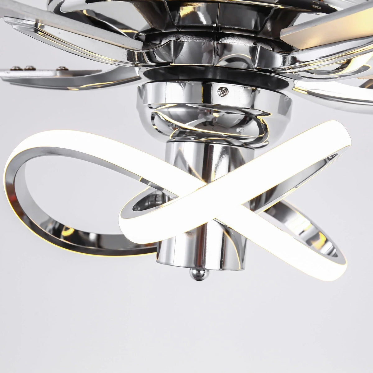 Close-up of chrome ceiling fan motor with mirrored blades and circular LED light