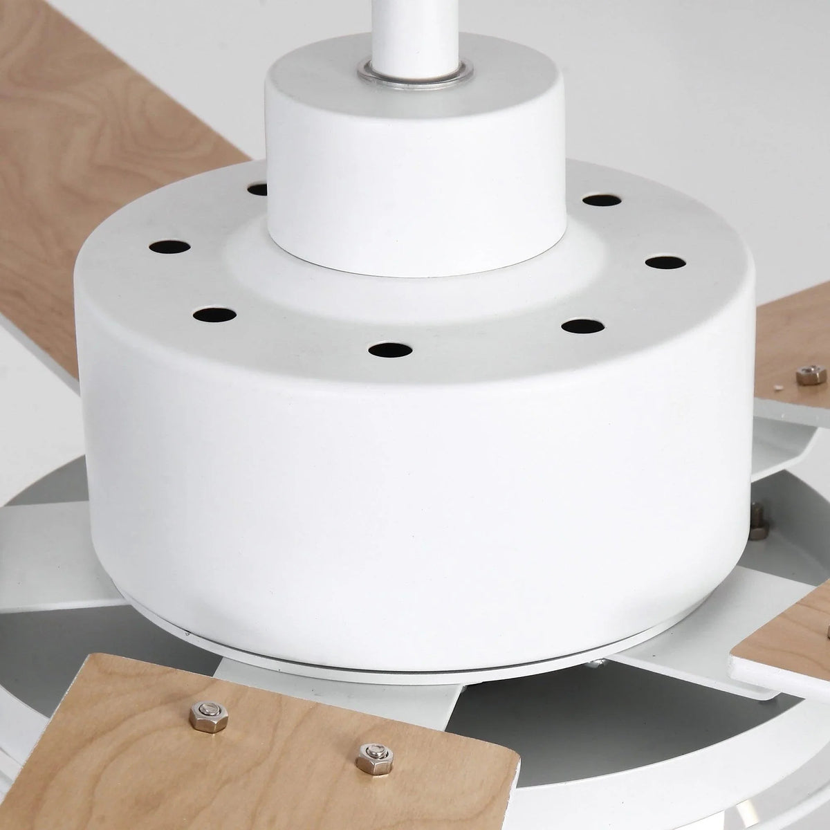 White ceiling fan motor cover with four light wood blades and hanging downrod