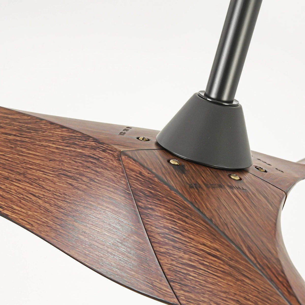 Close-up of brown wood-look ceiling fan blades and black motor housing