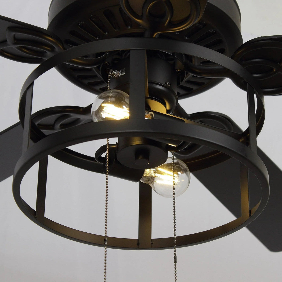 Close-up of black lantern ceiling fan light with warm exposed bulbs and metal frame
