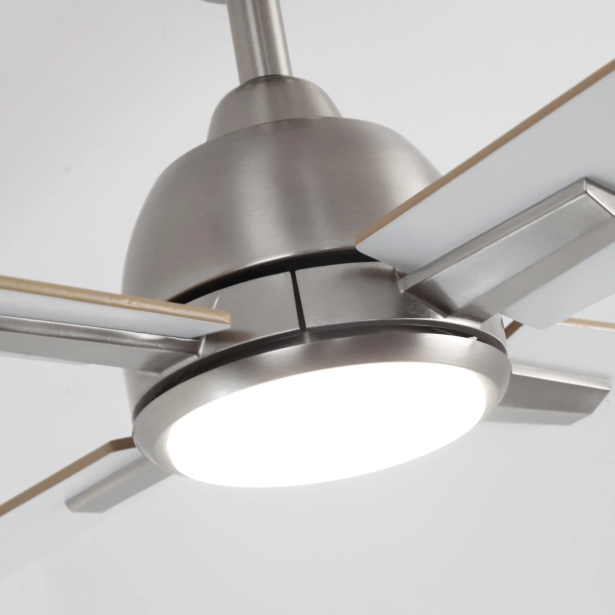 Close-up of satin nickel ceiling fan motor housing and round LED light