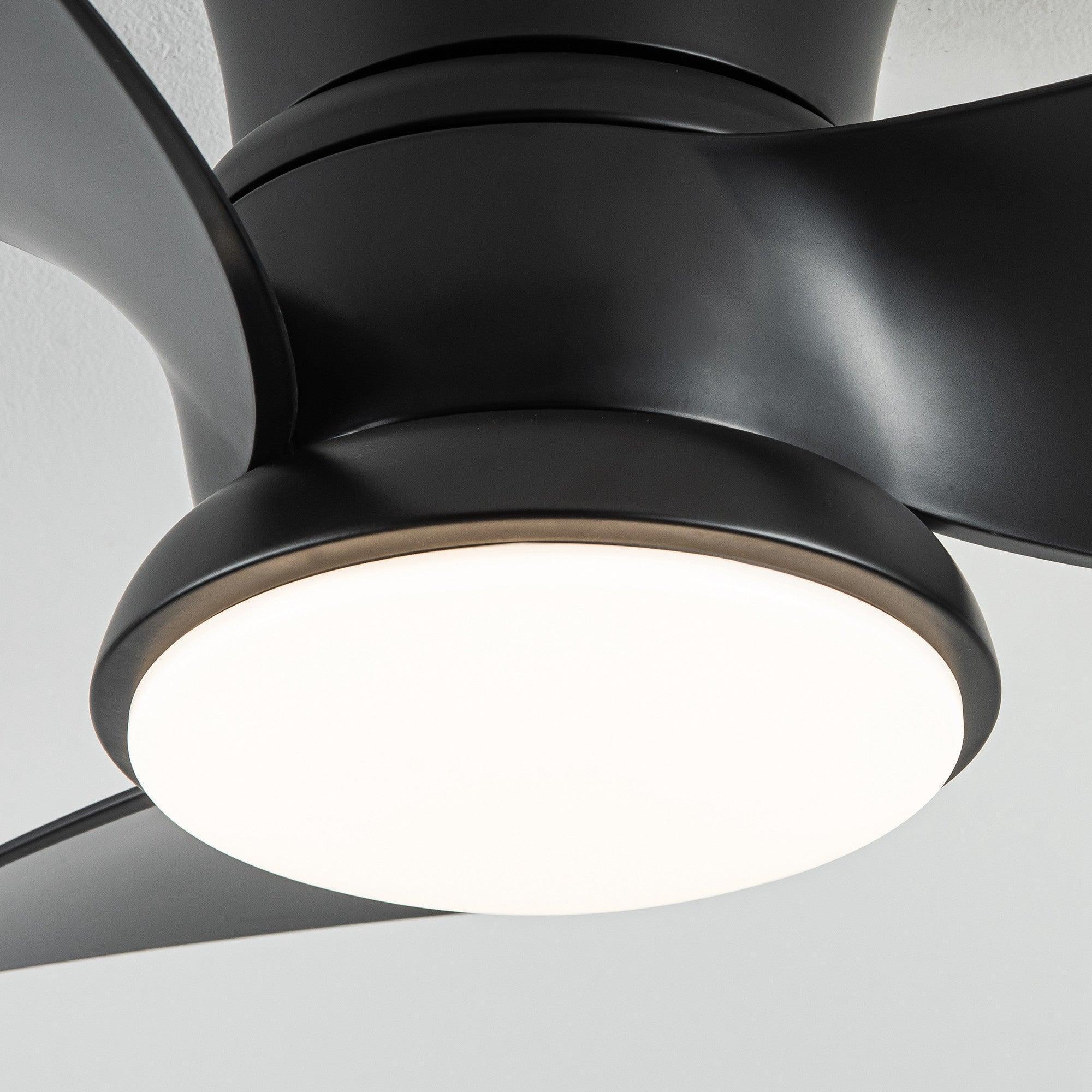 Close-up view of black flush mount ceiling fan with glowing round LED light