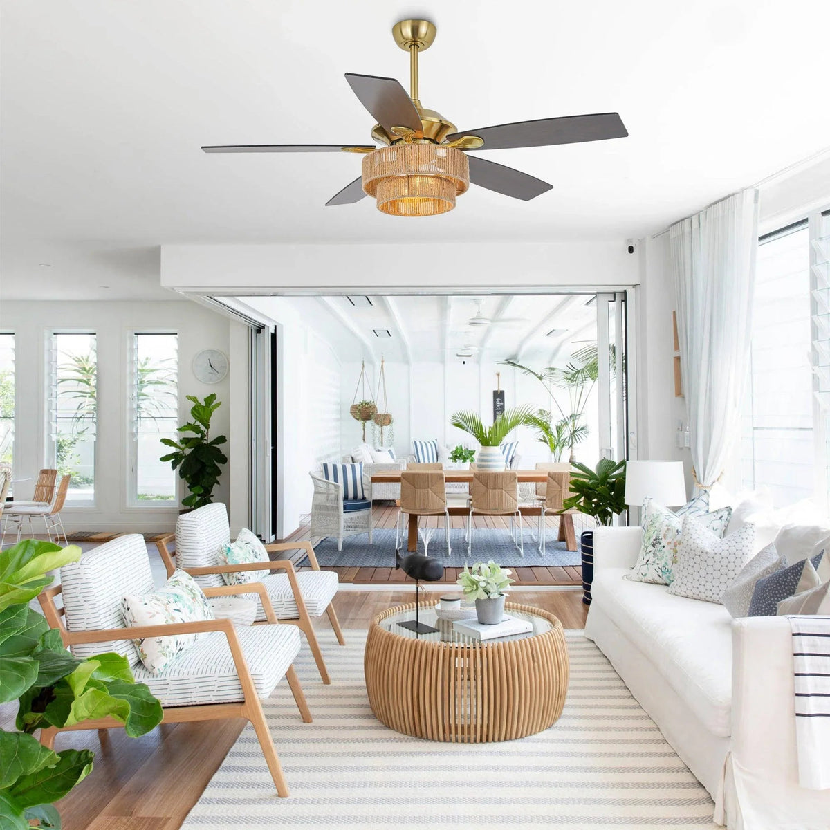 Golden ceiling fan with dark blades and wicker drum light shade