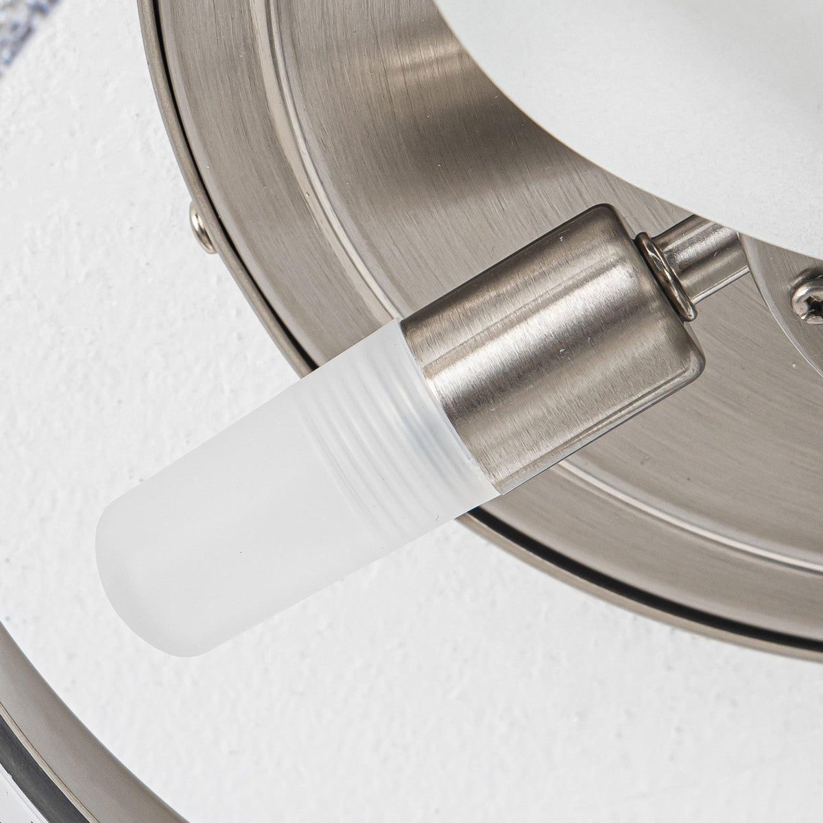Close-up of satin nickel ceiling fan downrod and frosted glass light shade