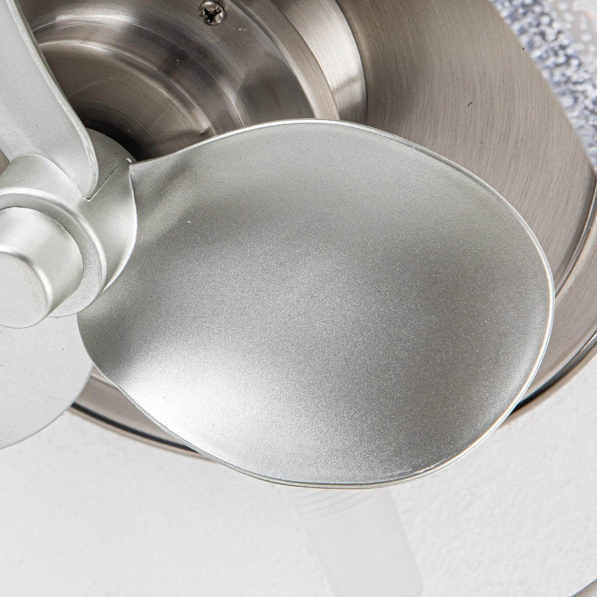 Close-up of satin nickel ceiling fan blade and frosted glass light cover