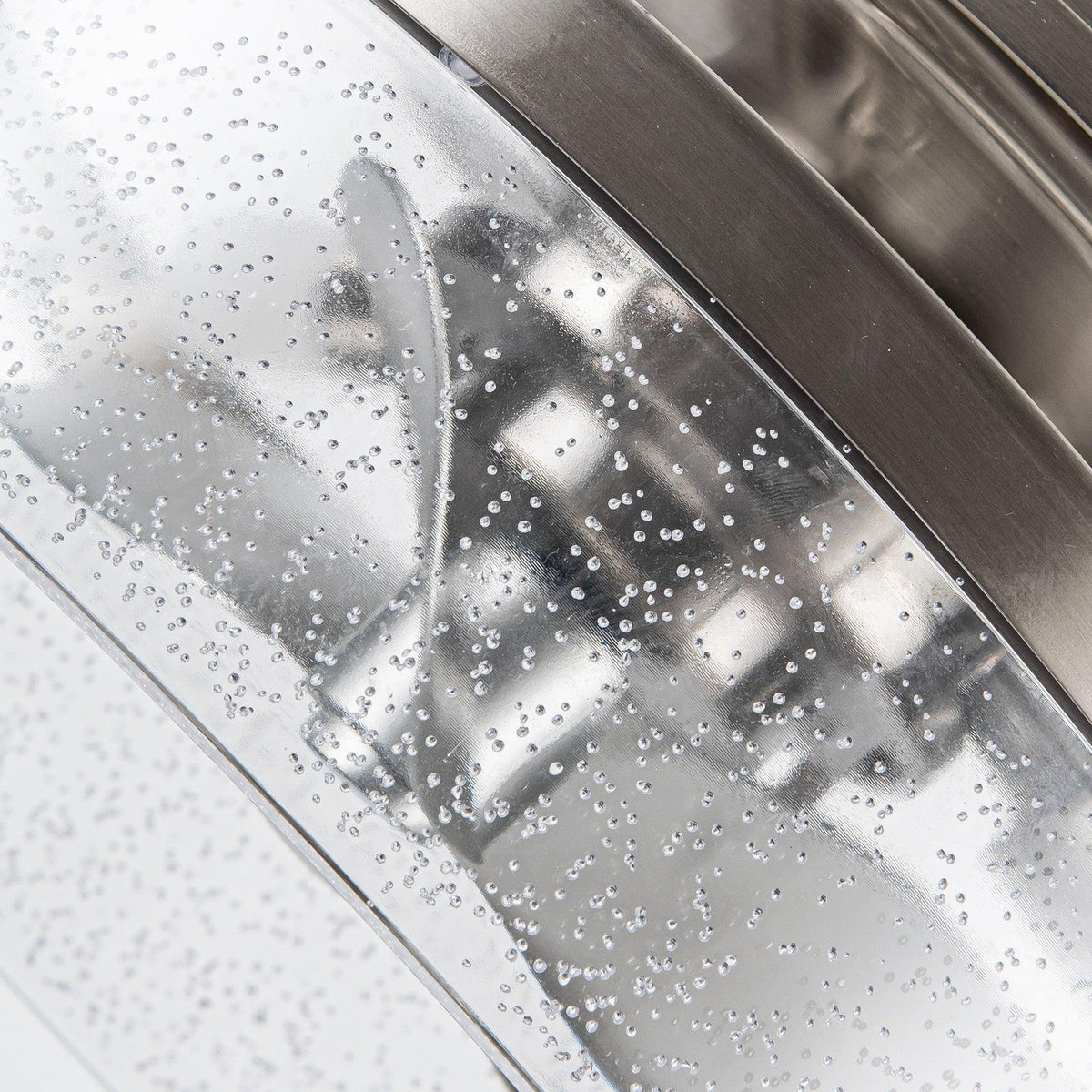 Close-up of frosted speckled glass shade on a satin nickel ceiling fan light