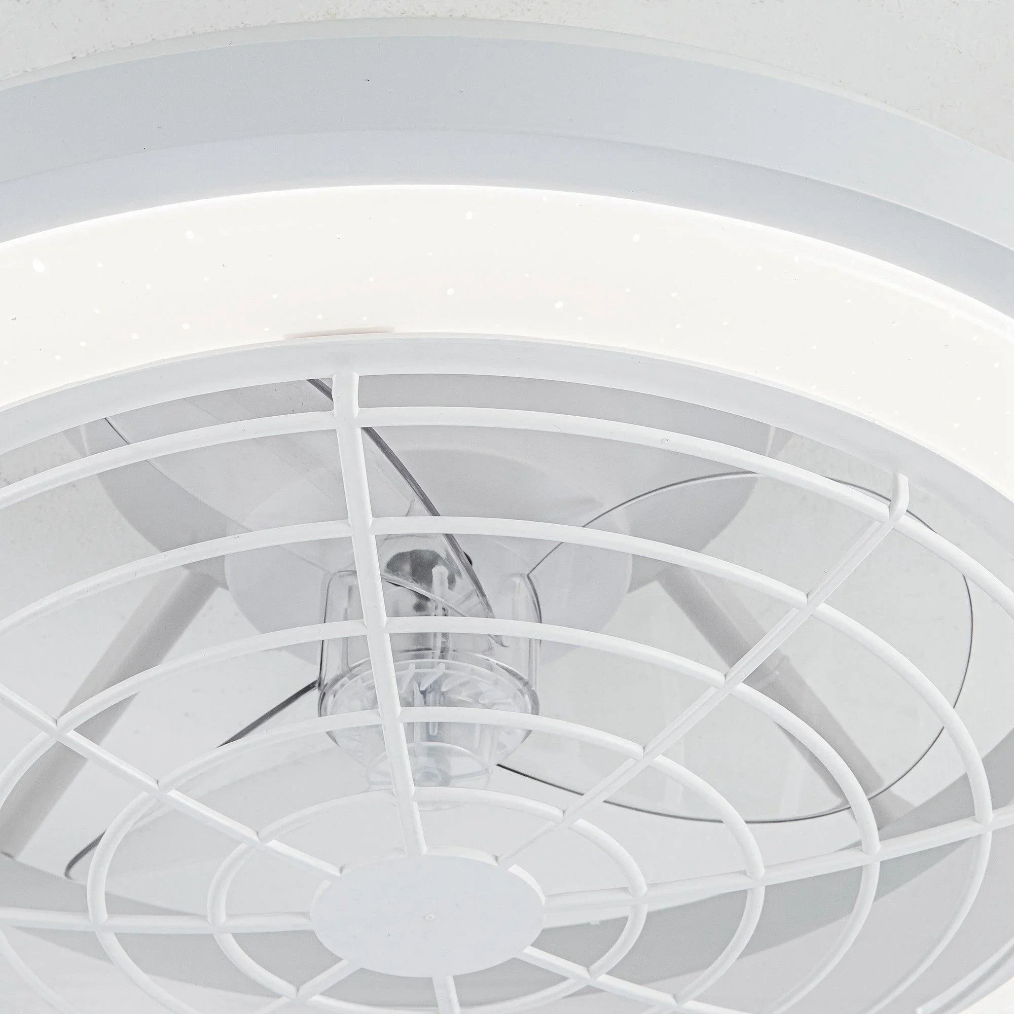 Close-up of white fan grille with cross bars and central light fixture.