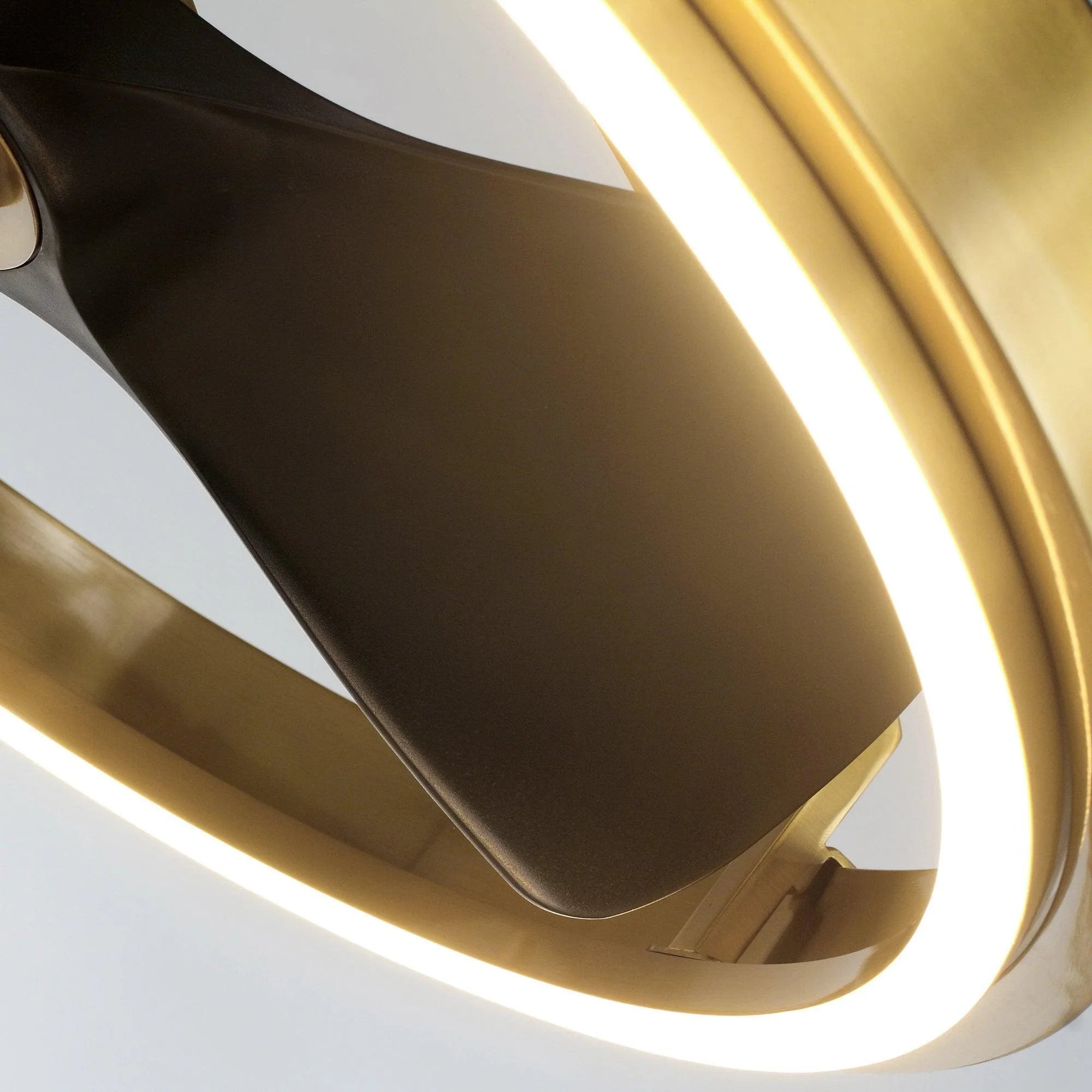 Golden ceiling fan blade curve and ring light edge close-up